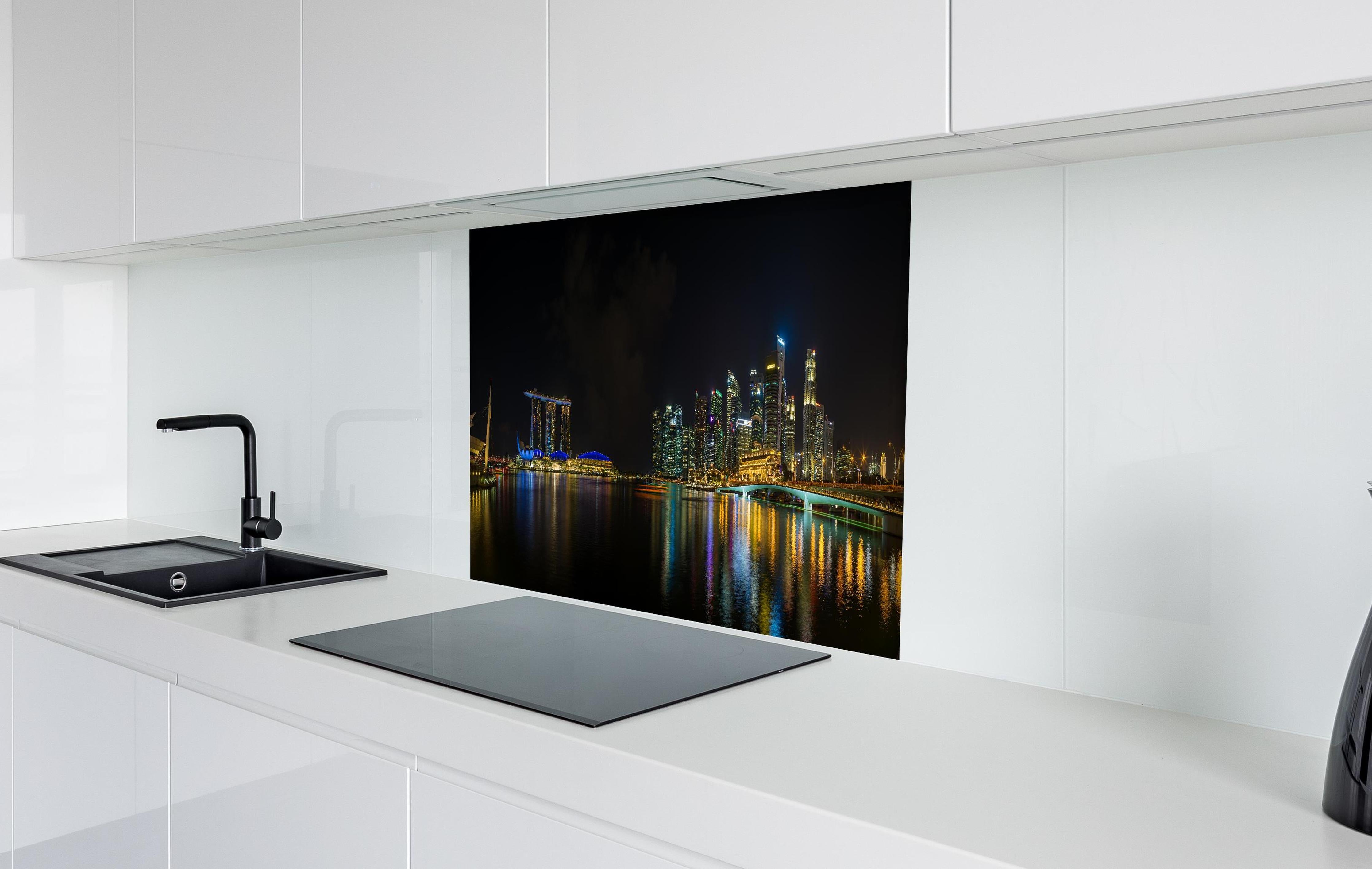 Spritzschutz - Marina Bay Sands bei Nacht hinter einem Cerankochfeld zwischen Holz-Kochutensilien