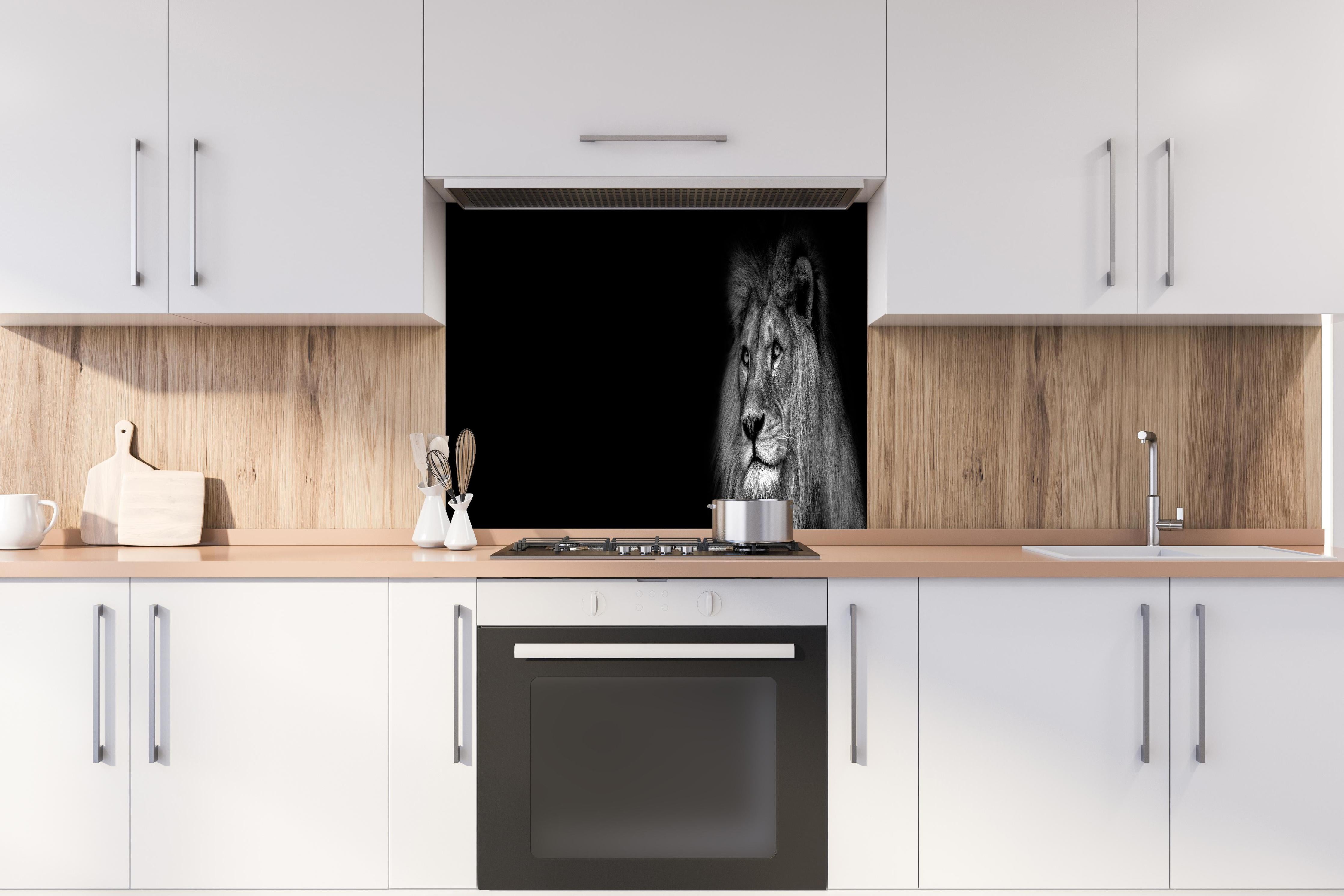 Spritzschutz - Markantes Löwen Gesicht Schwarz-Weiß hinter einem Cerankochfeld zwischen Holz-Kochutensilien