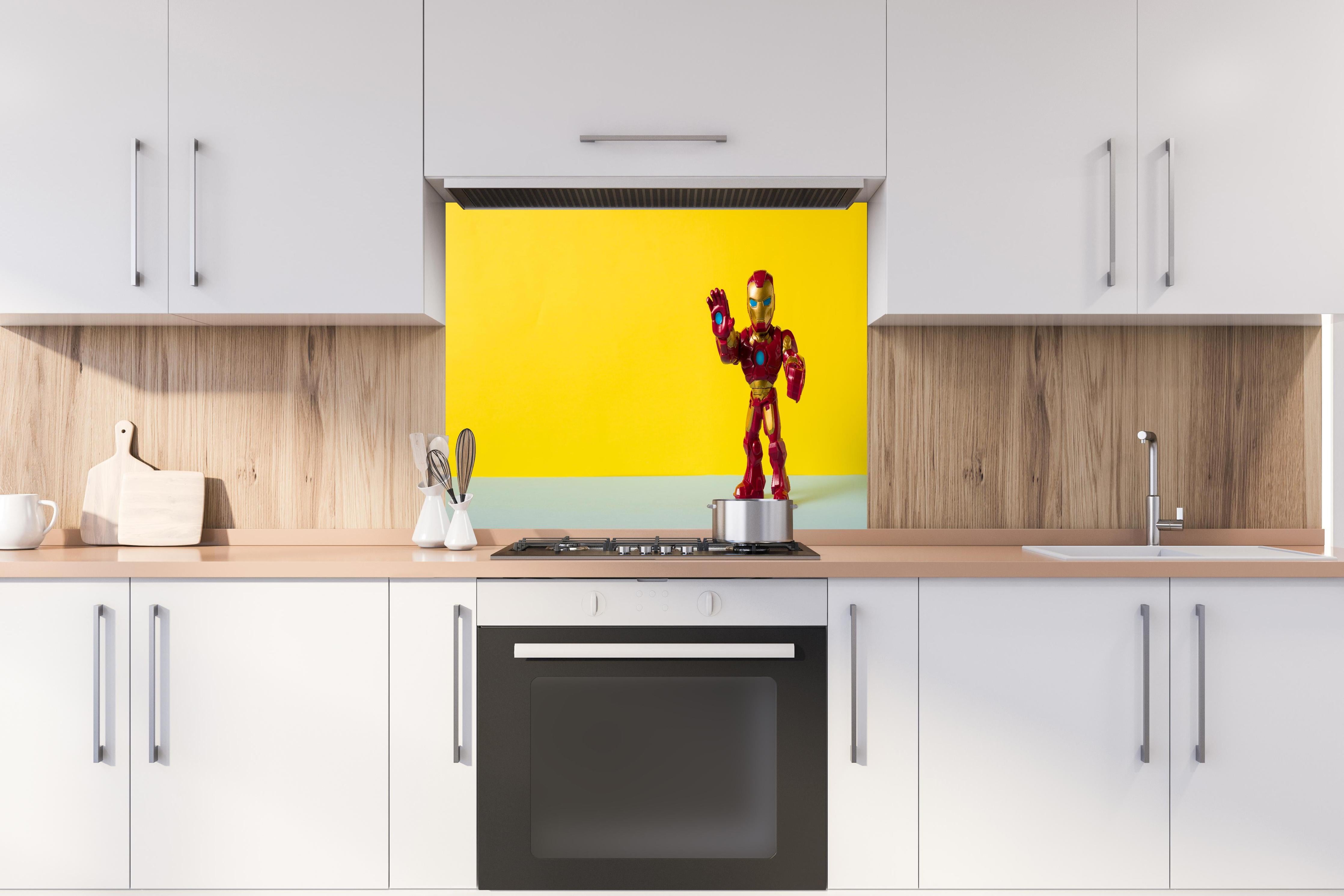 Spritzschutz - Marvel Iron Man Sammelfigur auf Gelb hinter einem Cerankochfeld zwischen Holz-Kochutensilien