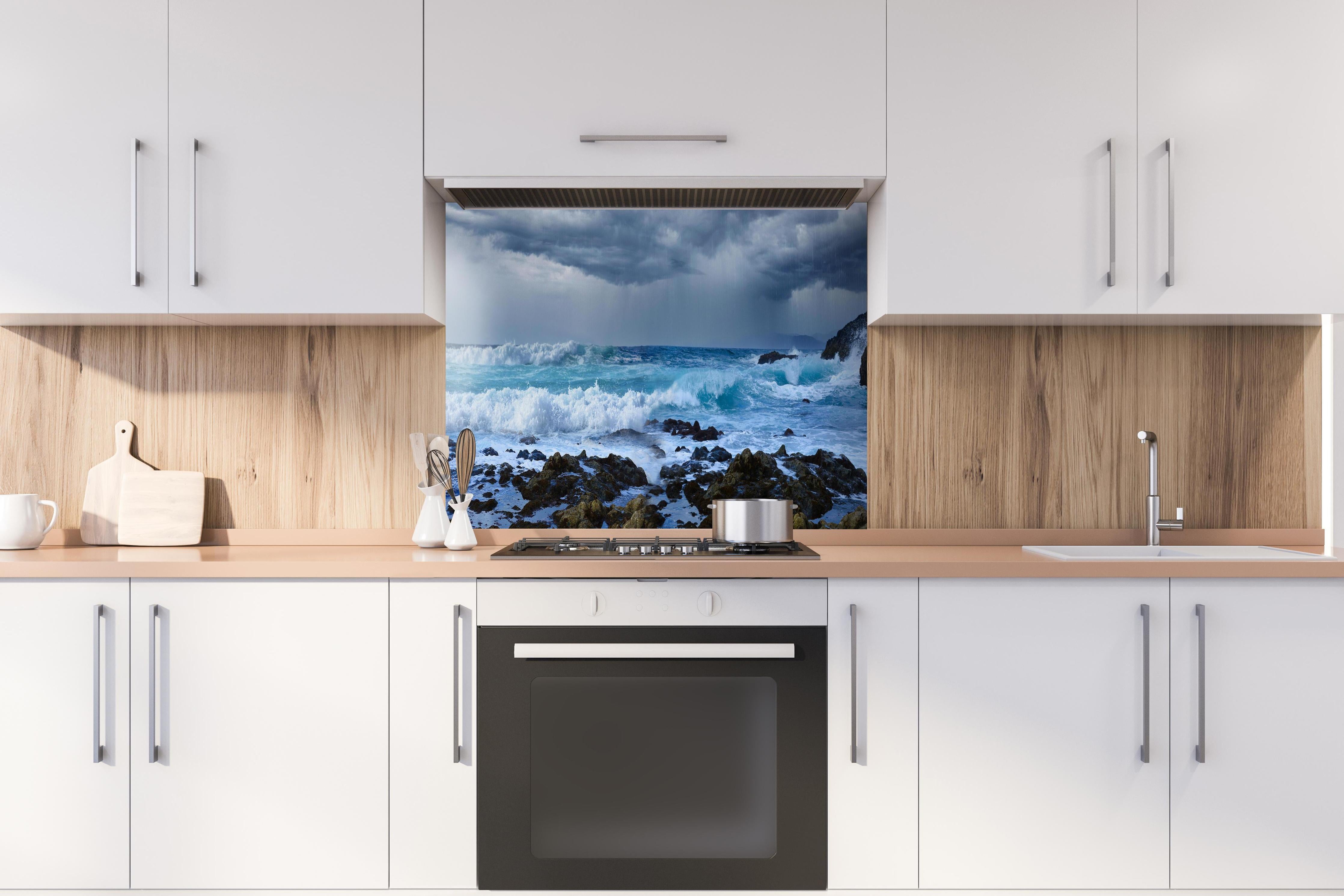 Spritzschutz - Meeresküste mit dunklen Regenwolken und stürmischer See hinter einem Cerankochfeld zwischen Holz-Kochutensilien