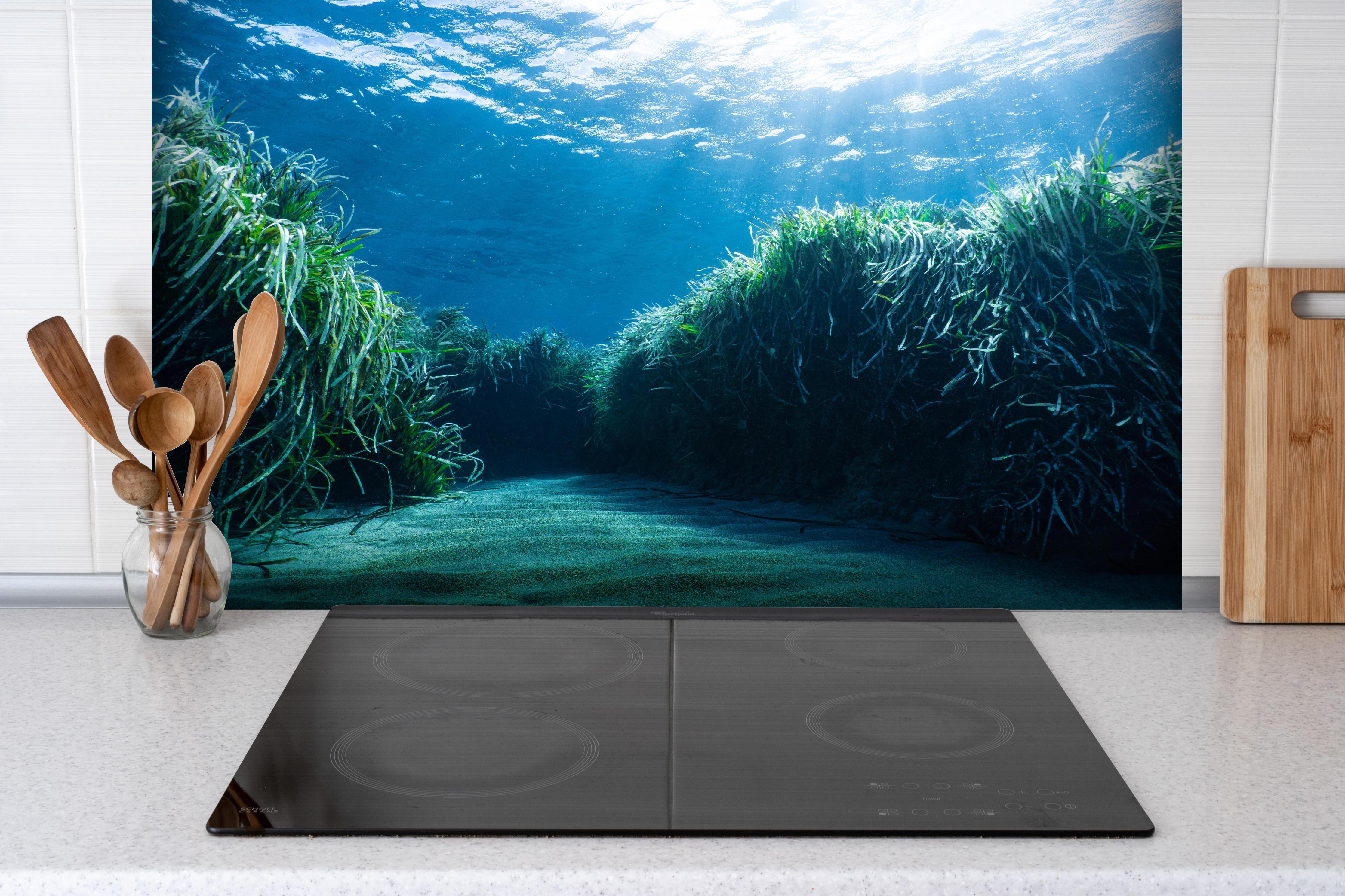 Spritzschutz - Mesmerizing Unterwasser hinter einem Cerankochfeld zwischen Holz-Kochutensilien