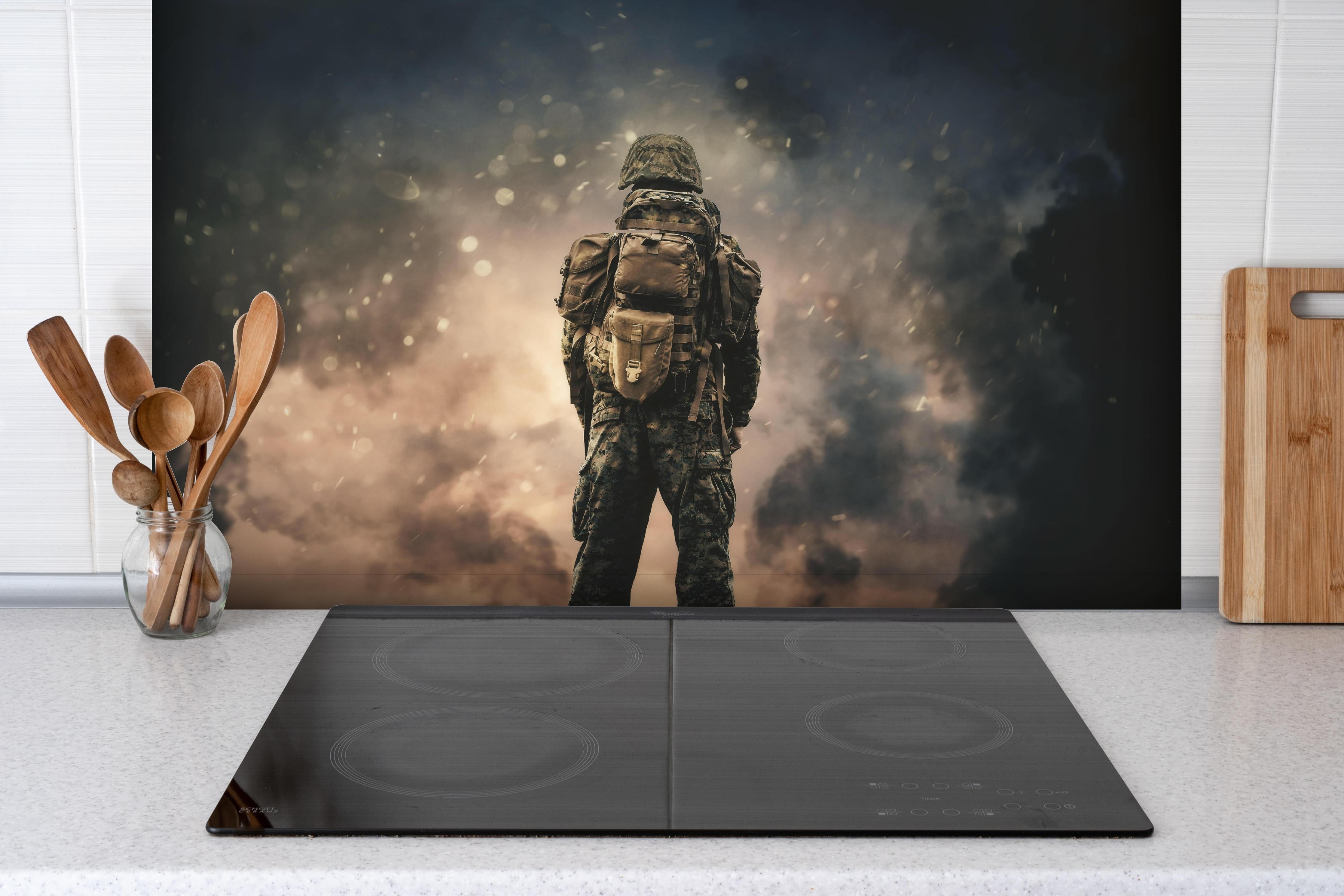 Spritzschutz - Militärsoldat zwischen Rauch und Staub hinter einem Cerankochfeld zwischen Holz-Kochutensilien