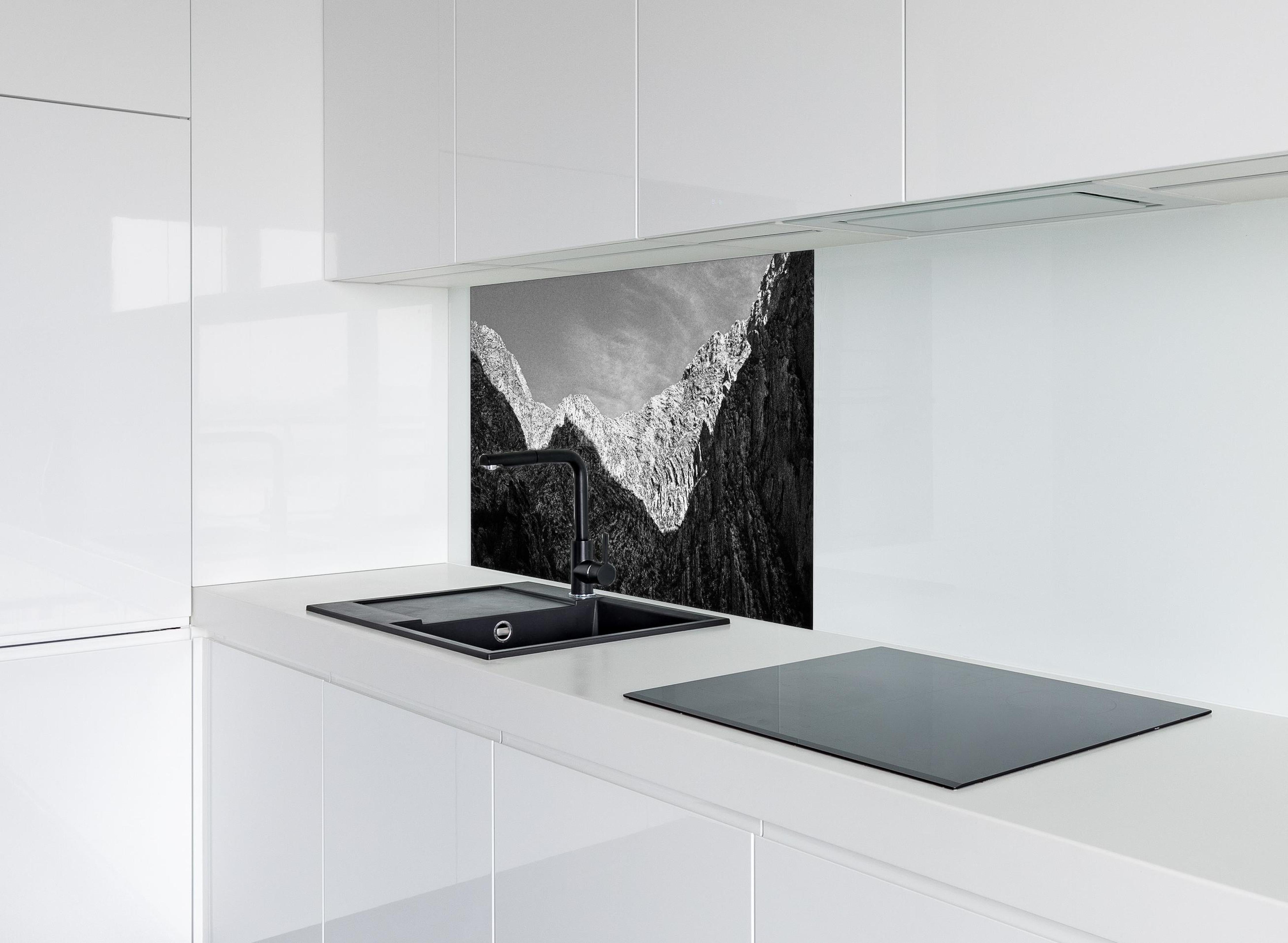 Spritzschutz - Minimalistische Berglandschaft in Schwarz-Weiß hinter einem Cerankochfeld zwischen Holz-Kochutensilien