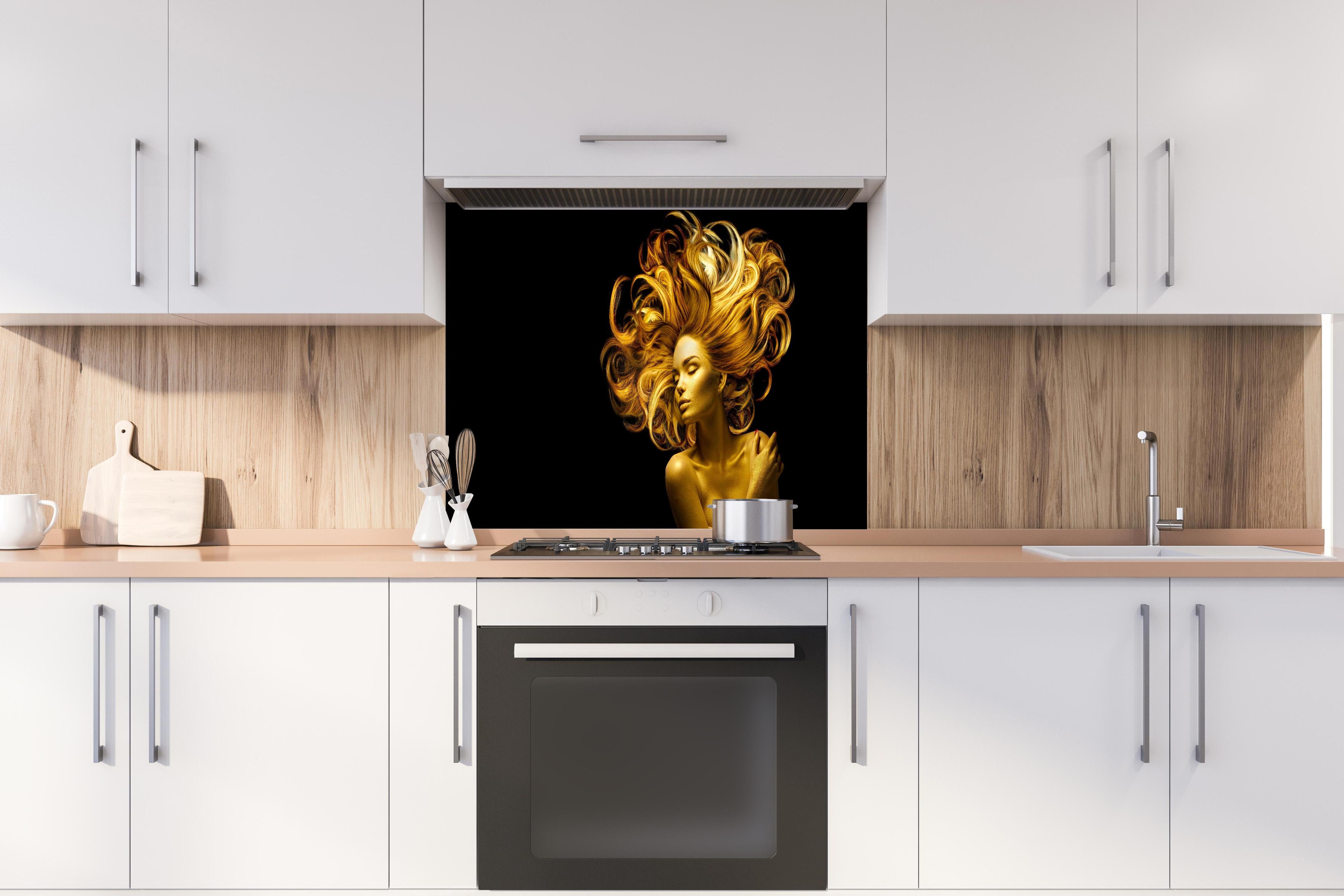 Spritzschutz - Model in Gold hinter einem Cerankochfeld zwischen Holz-Kochutensilien