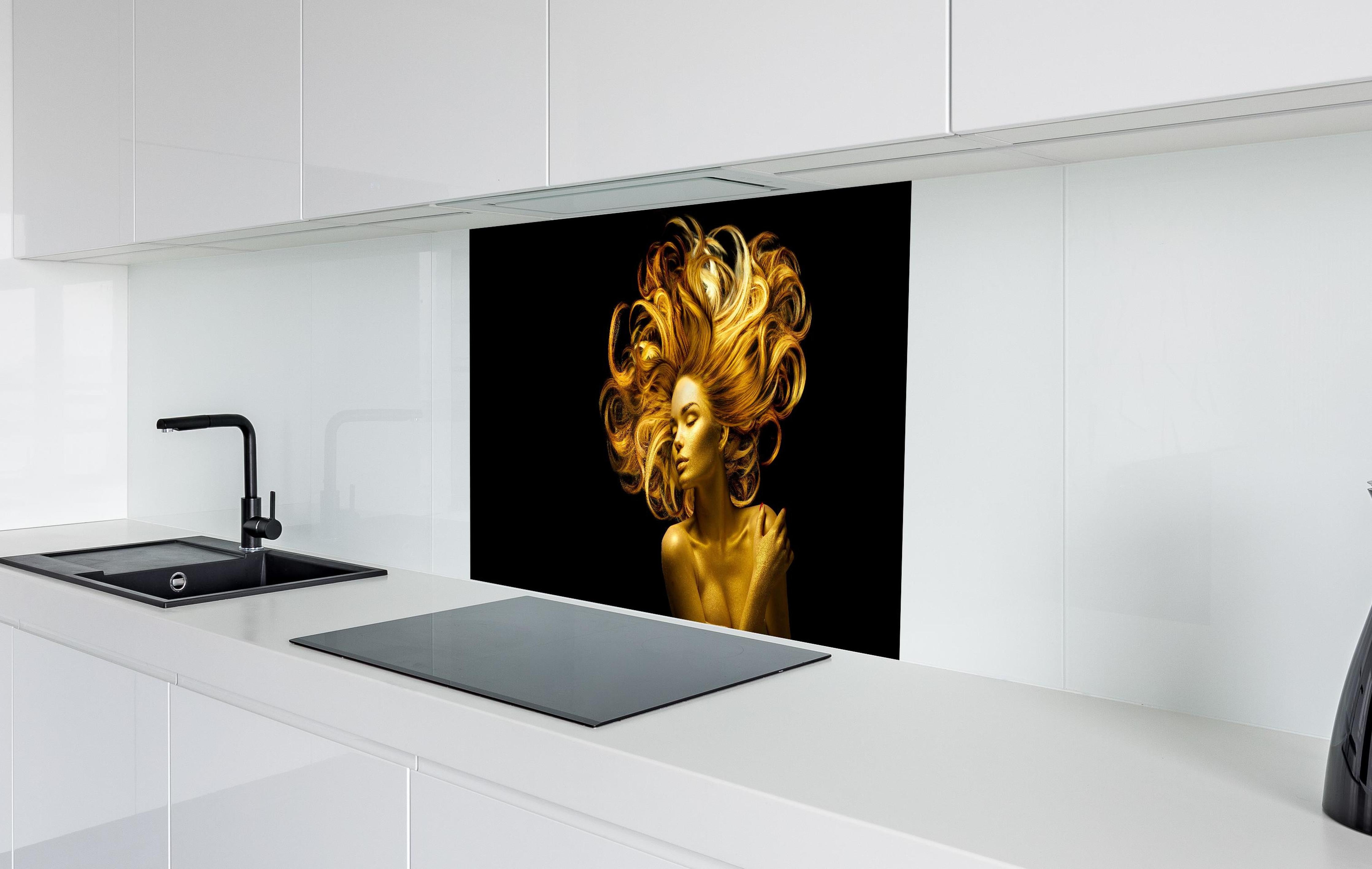 Spritzschutz - Model in Gold hinter einem Cerankochfeld zwischen Holz-Kochutensilien