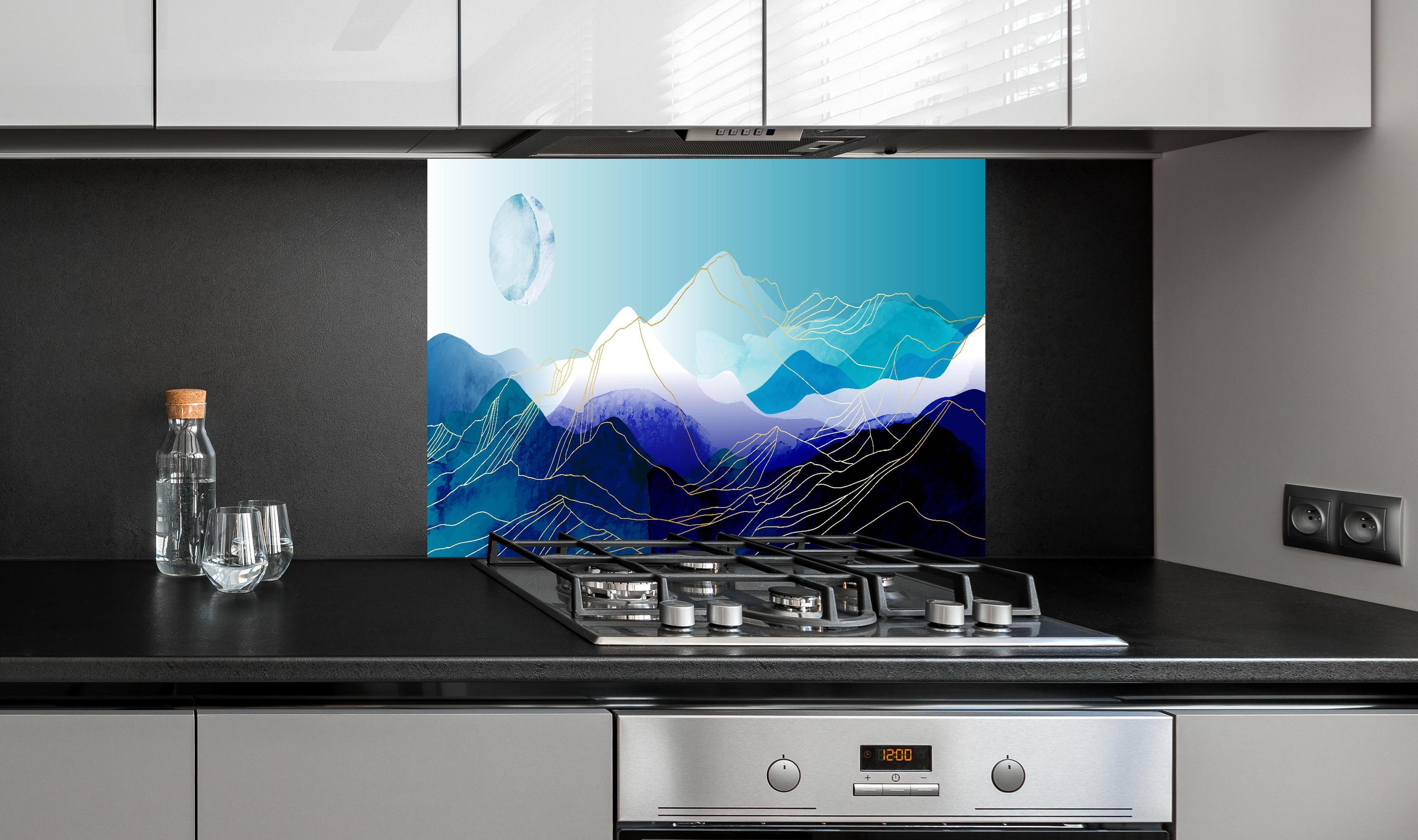 Spritzschutz - Moderne Berg-Silhouetten gegen Mondhimmel hinter einem Cerankochfeld zwischen Holz-Kochutensilien