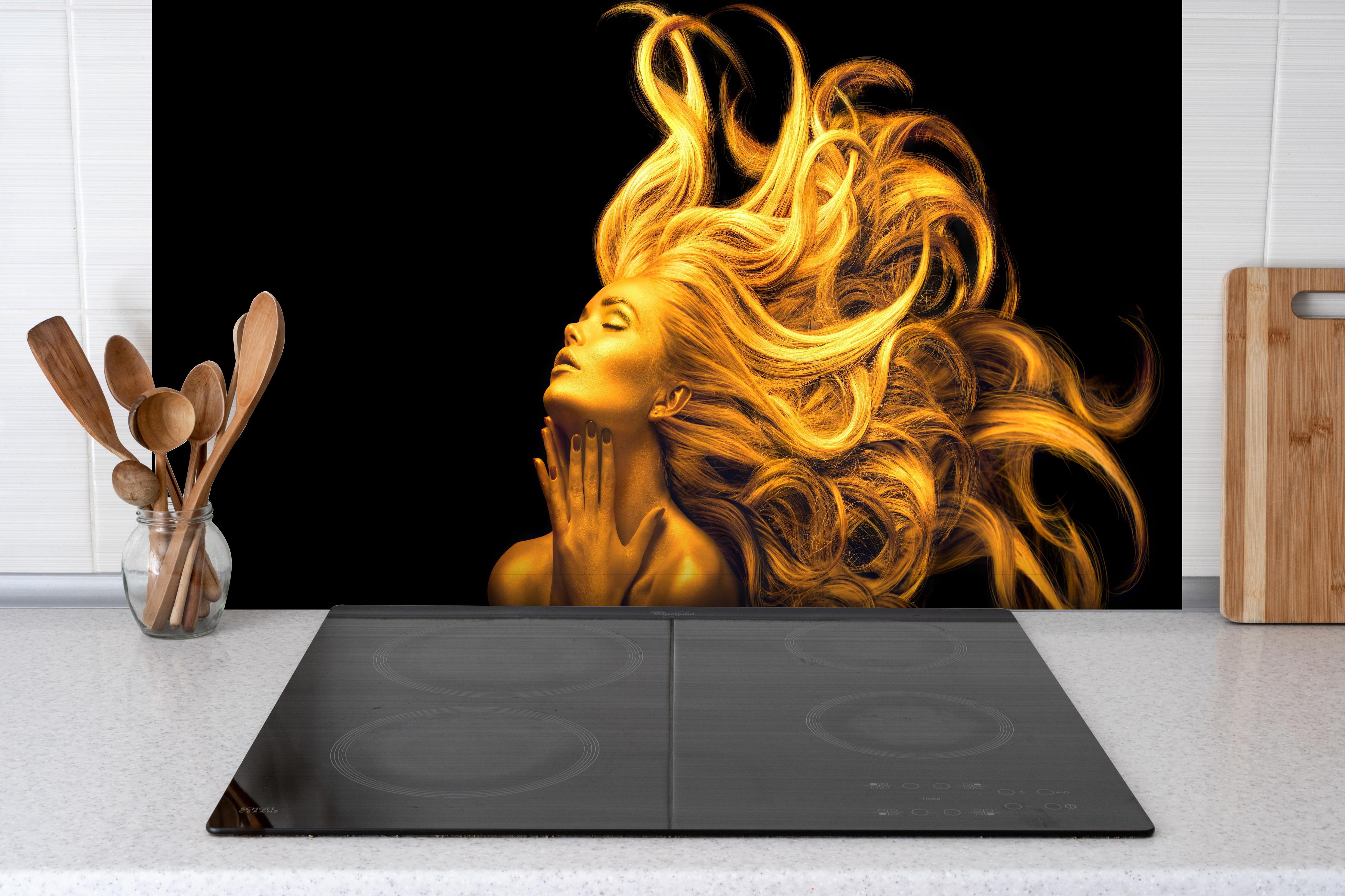 Spritzschutz - Moderne Darstellung einer vergoldeten Frau hinter einem Cerankochfeld zwischen Holz-Kochutensilien