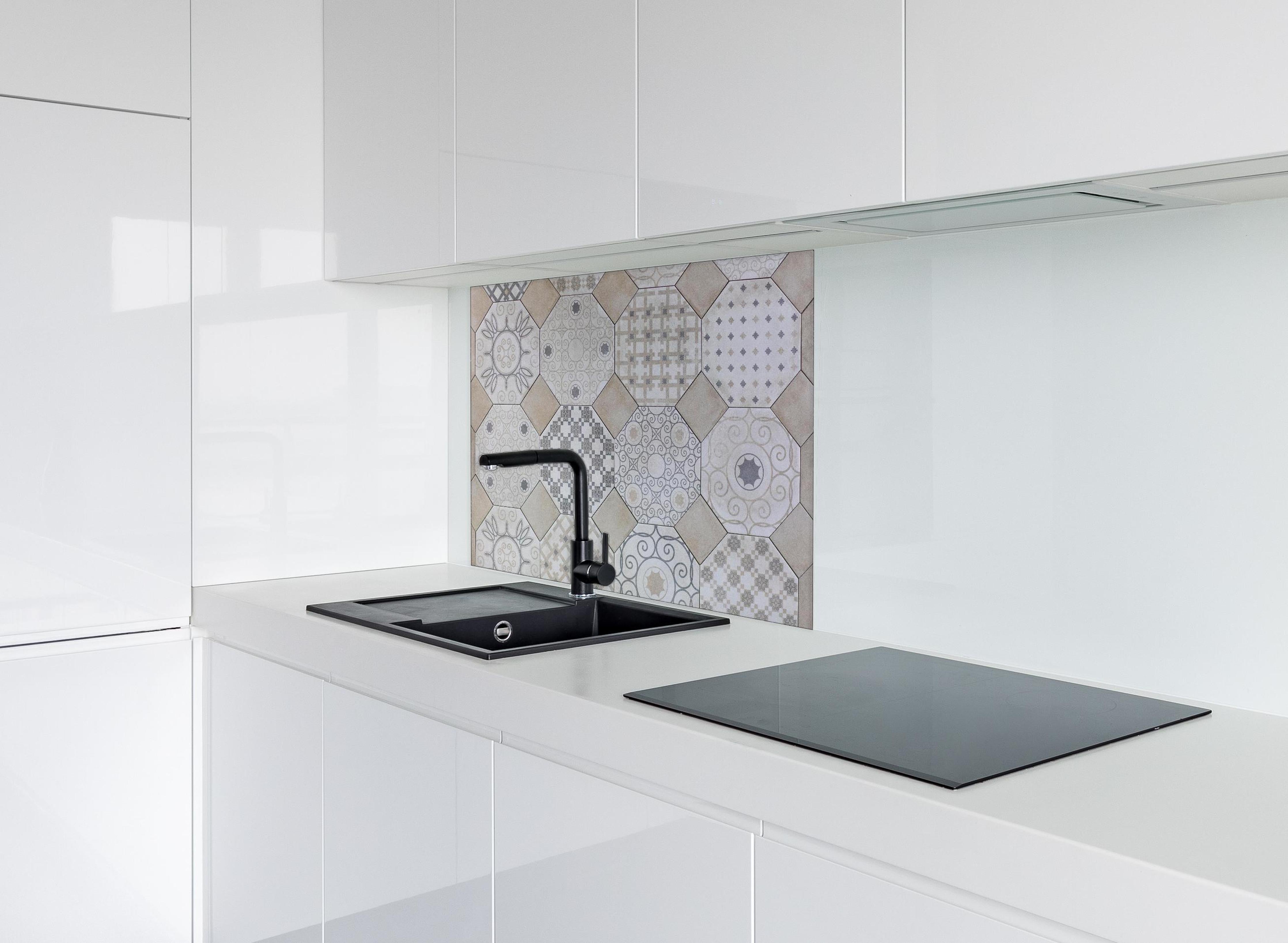 Spritzschutz - Moderne Hexagon-Fliesen in Weiß und Grau hinter einem Cerankochfeld zwischen Holz-Kochutensilien