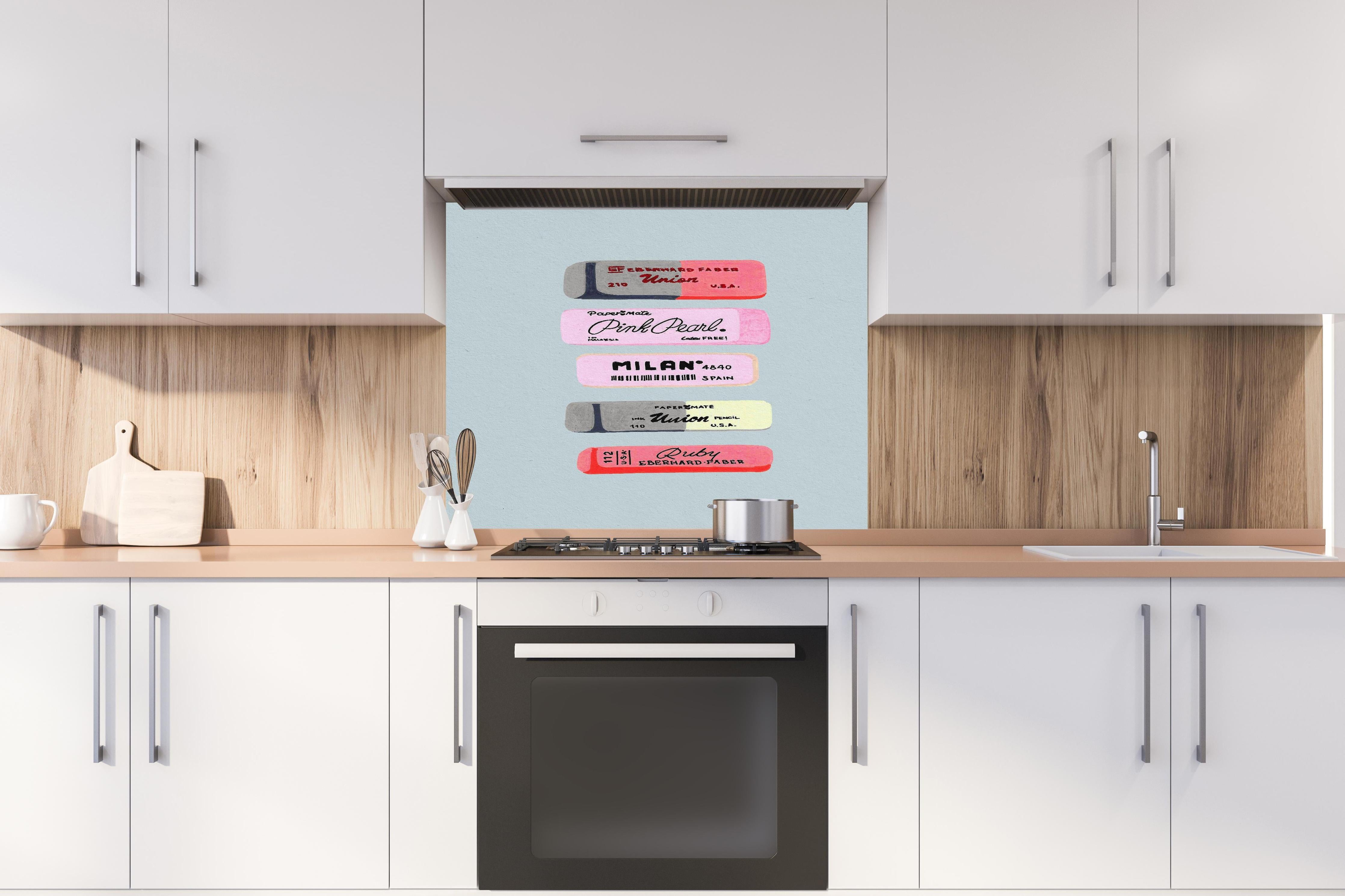 Spritzschutz - Moderne Radiergummis - Pastellfarben hinter einem Cerankochfeld zwischen Holz-Kochutensilien