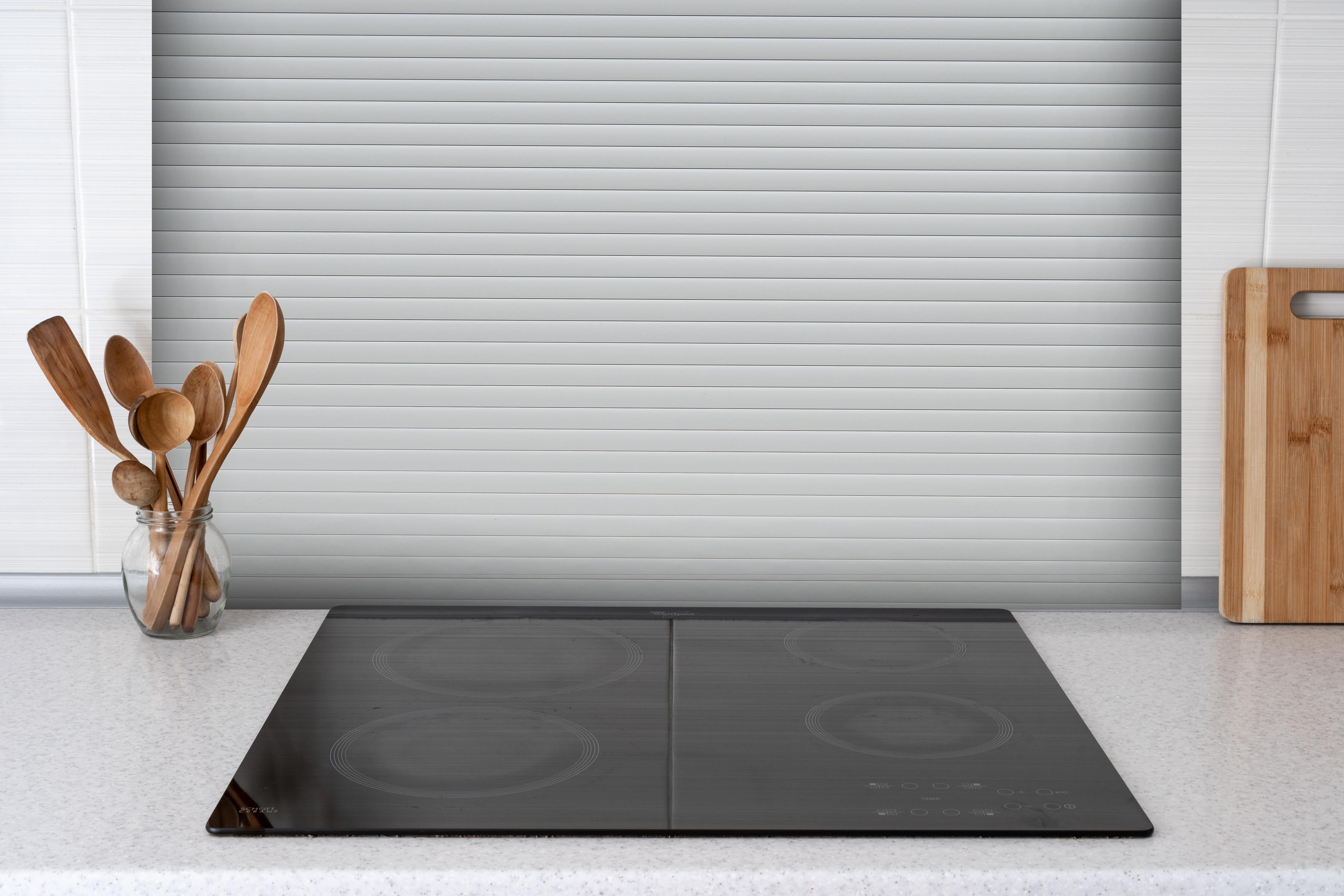 Spritzschutz - Moderne Weiß-Graue Lamellen Wandverkleidung hinter einem Cerankochfeld zwischen Holz-Kochutensilien