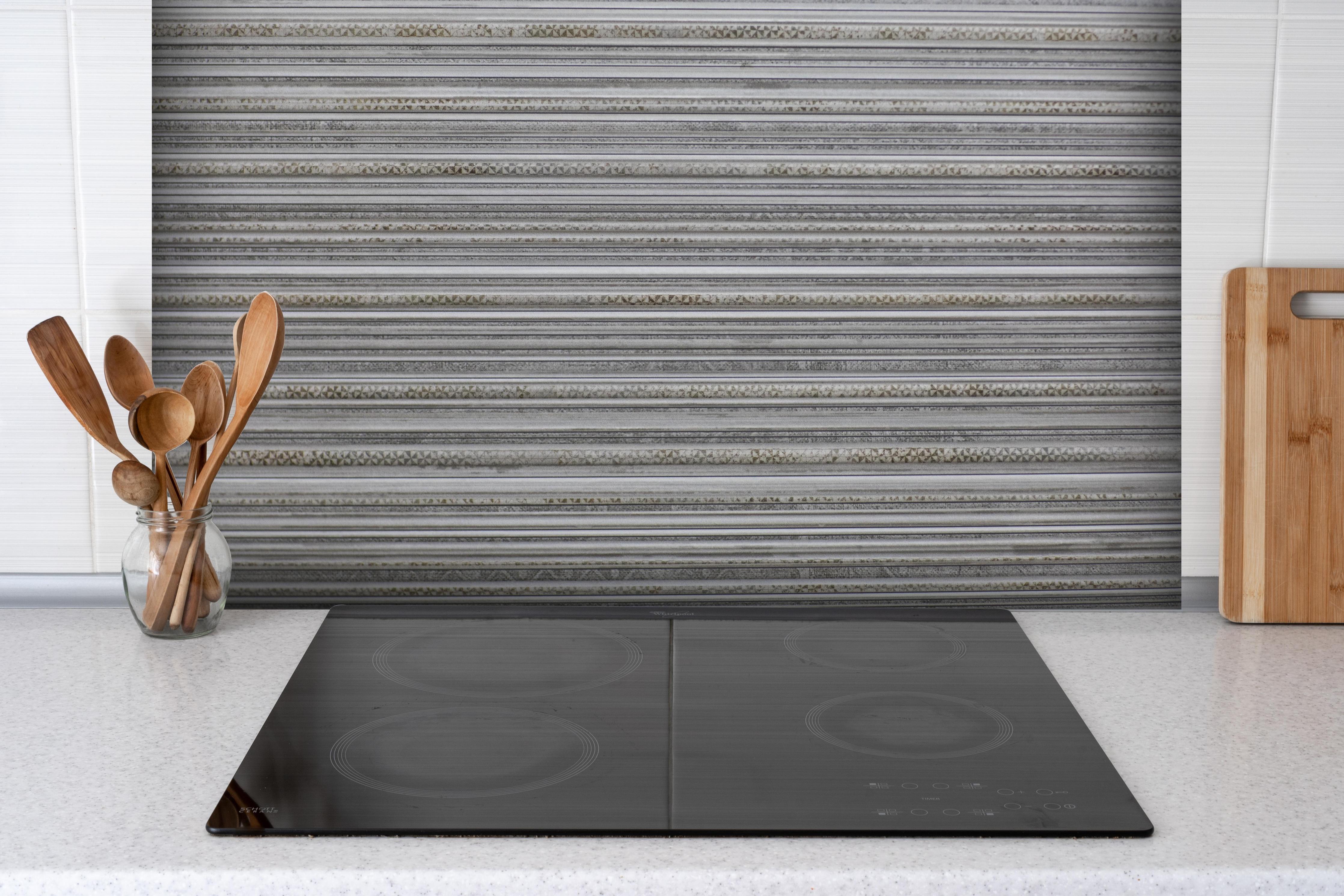 Spritzschutz - Moderne grau-weiße Linien Fliesentextur hinter einem Cerankochfeld zwischen Holz-Kochutensilien