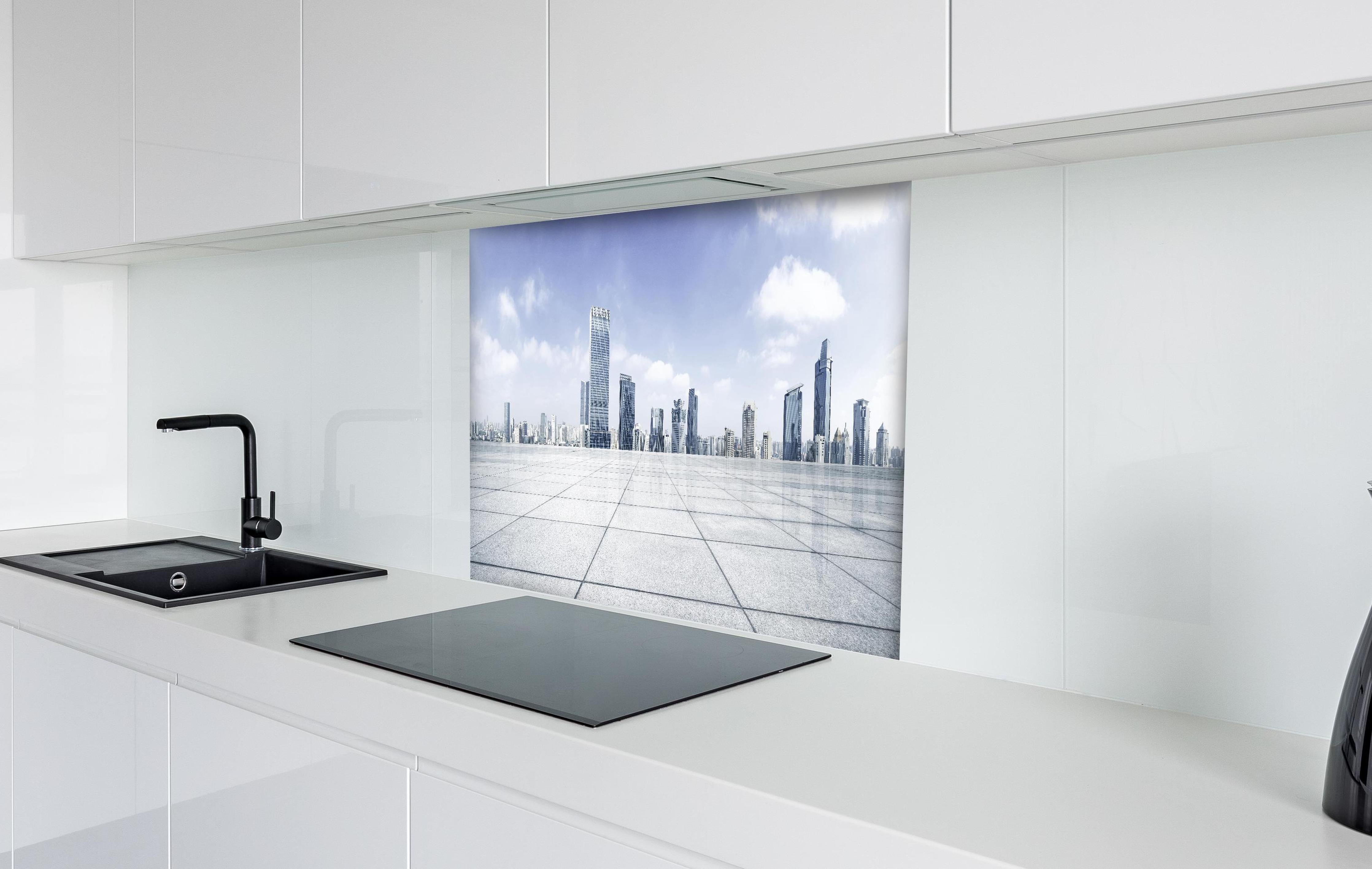 Spritzschutz - Moderner Skyline und Gebäuden hinter einem Cerankochfeld zwischen Holz-Kochutensilien