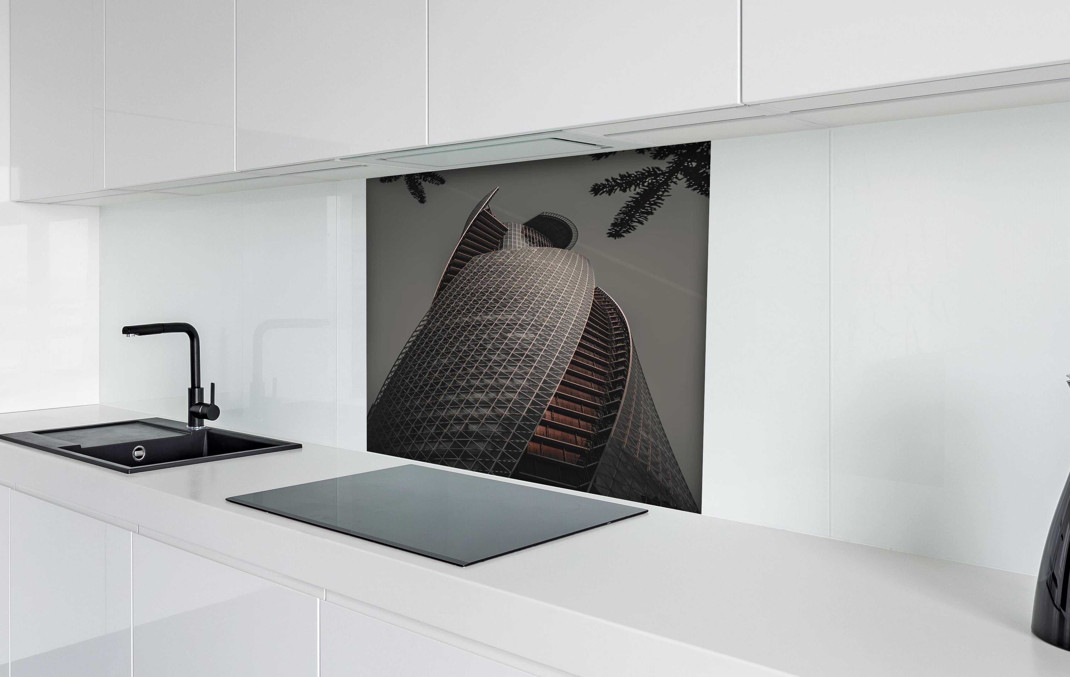 Spritzschutz - Modernes Spiral-Gebäude in Grautönen hinter einem Cerankochfeld zwischen Holz-Kochutensilien