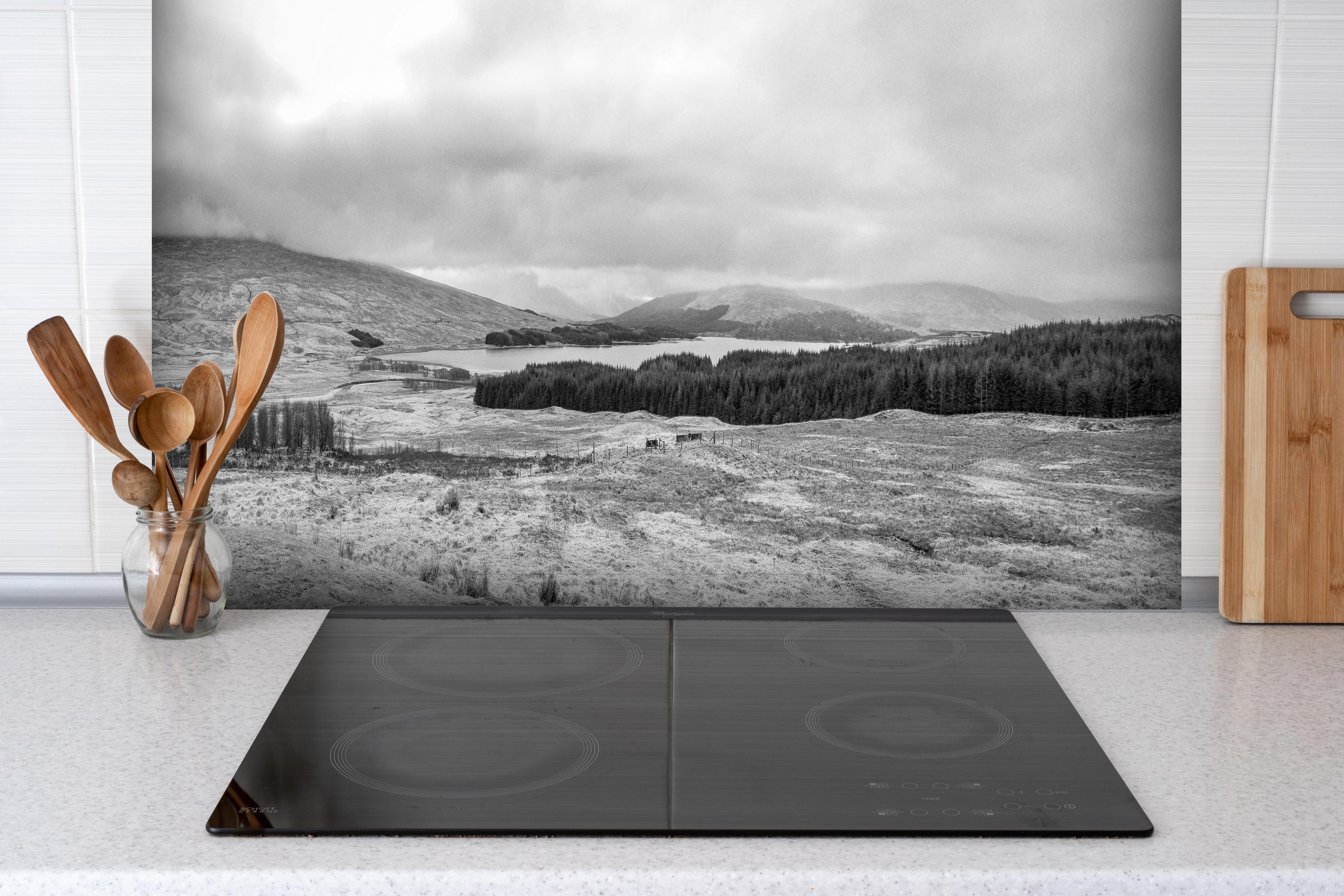 Spritzschutz - Monochrome Winterlandschaft Highlands hinter einem Cerankochfeld zwischen Holz-Kochutensilien