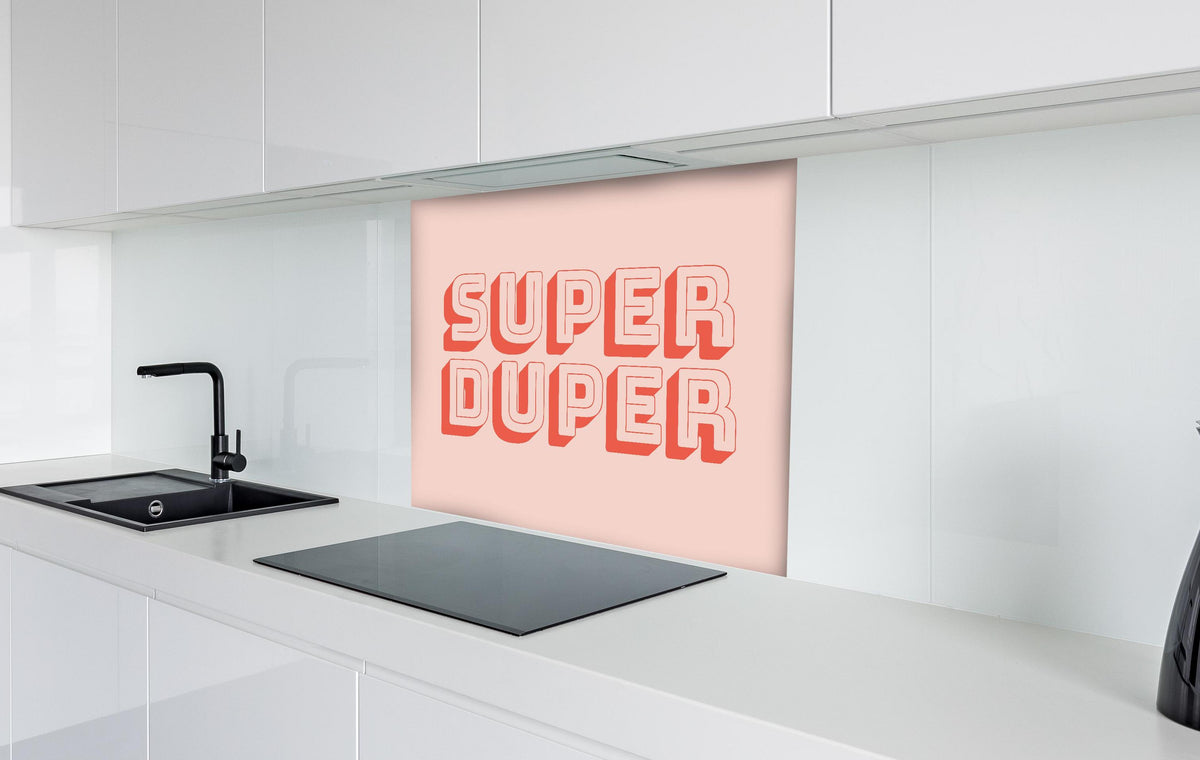 Spritzschutz - Motivationaler 'Super Duper' Schriftzug in Pink hinter einem Cerankochfeld zwischen Holz-Kochutensilien