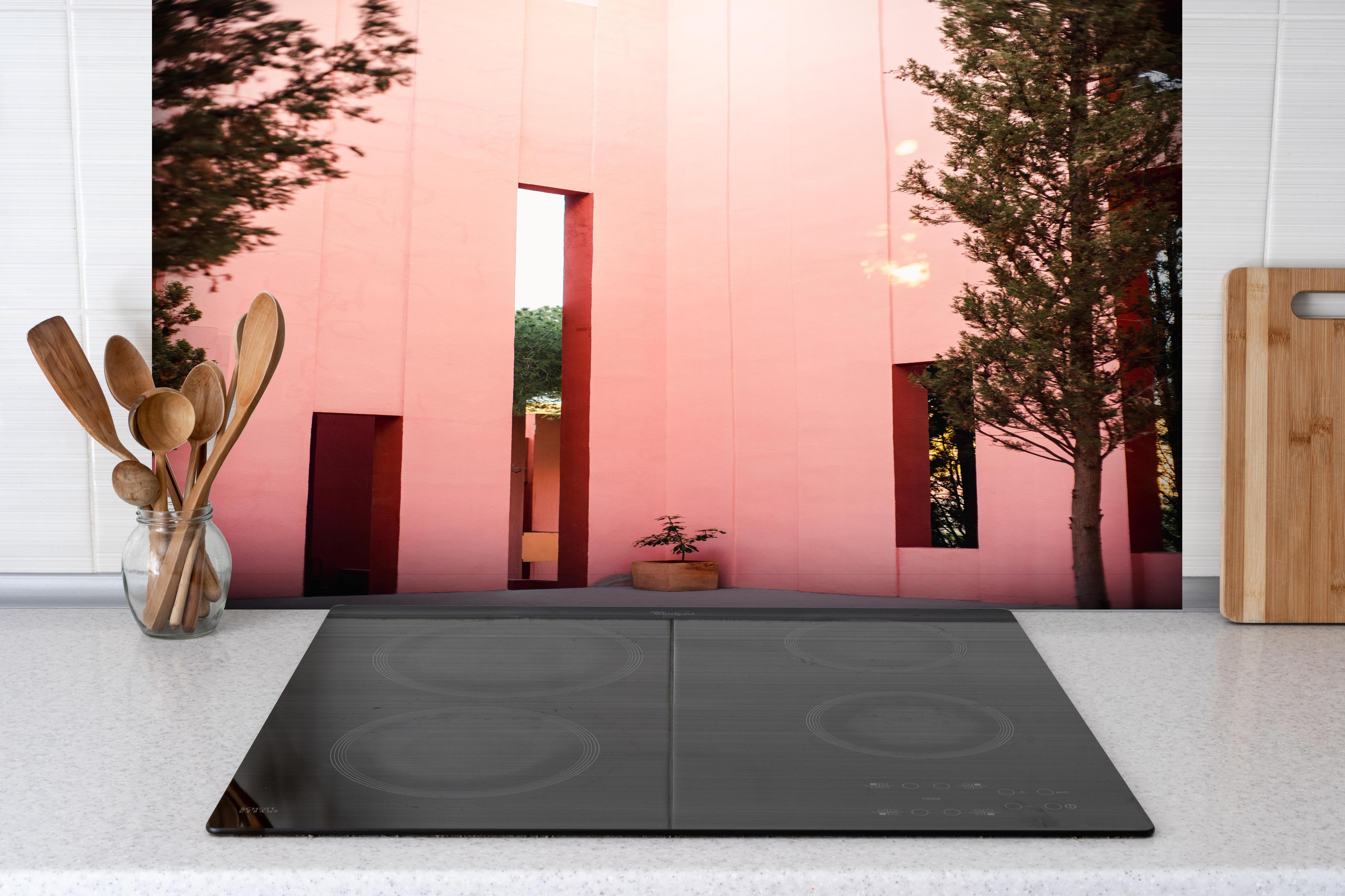 Spritzschutz - Muralla Roja Eingang in zartem Pink hinter einem Cerankochfeld zwischen Holz-Kochutensilien