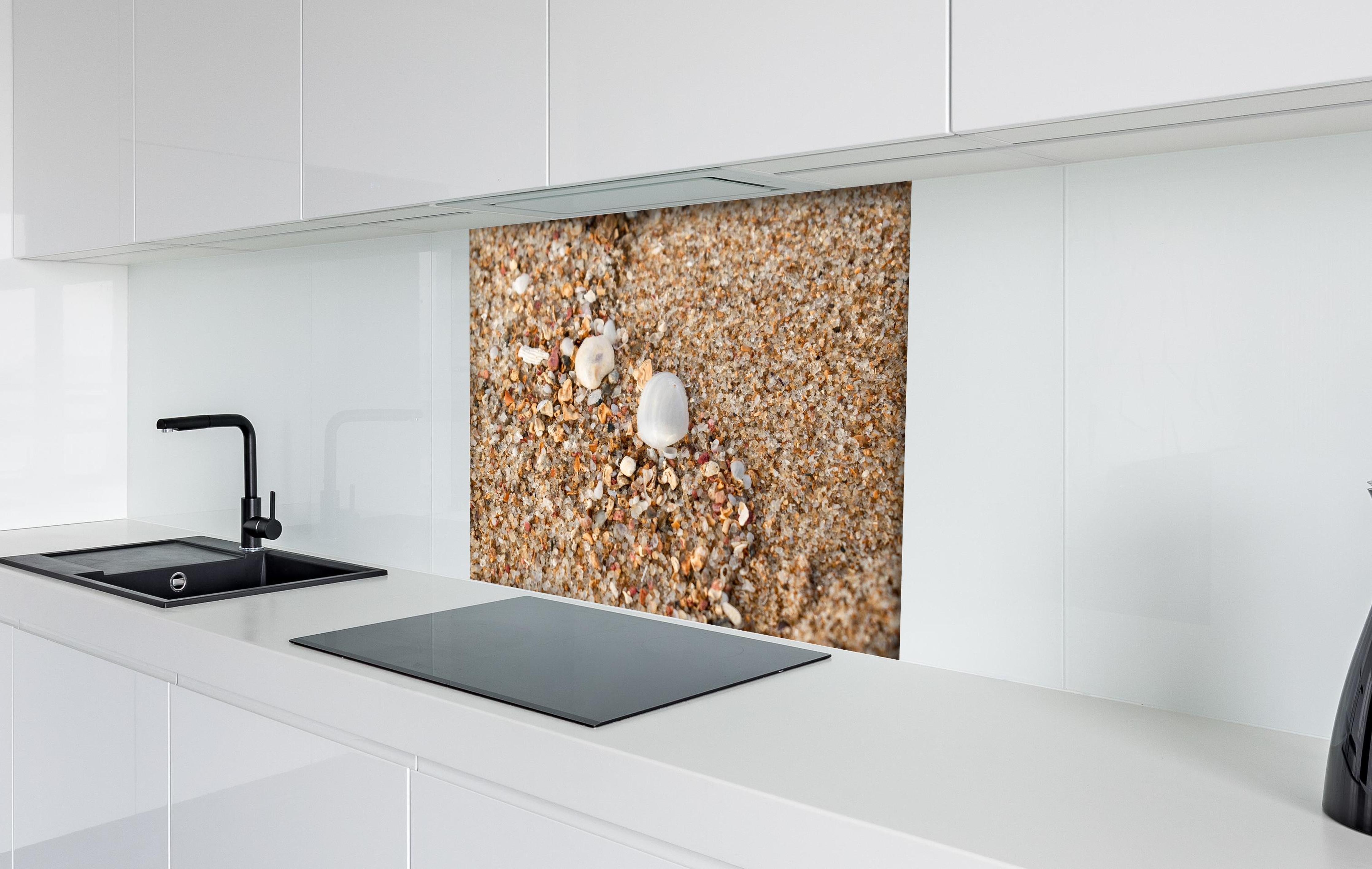 Spritzschutz - Muscheln im Strandsand. Shell hinter einem Cerankochfeld zwischen Holz-Kochutensilien