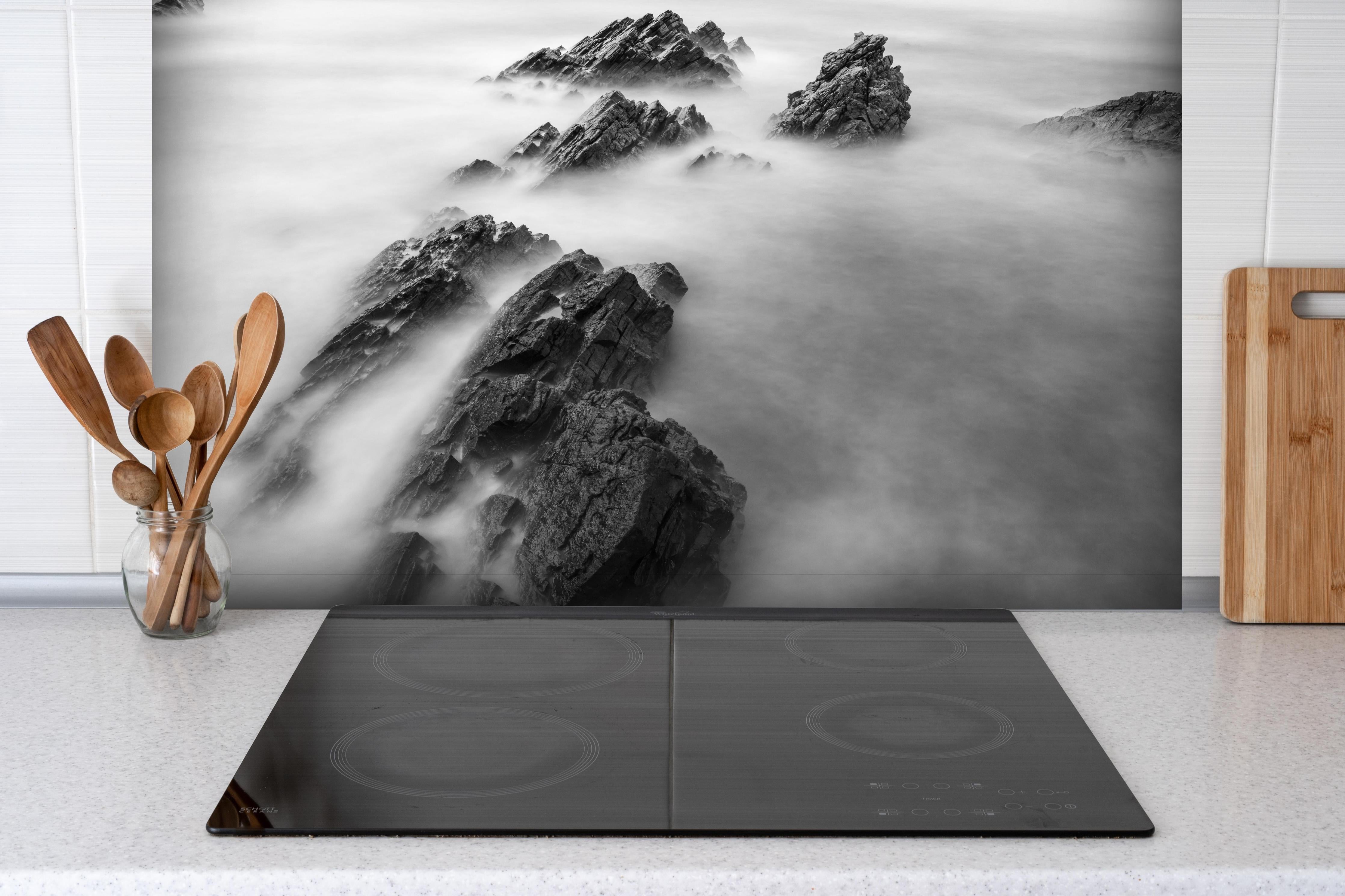 Spritzschutz - Mystische Felsformationen im Nebelmeer hinter einem Cerankochfeld zwischen Holz-Kochutensilien