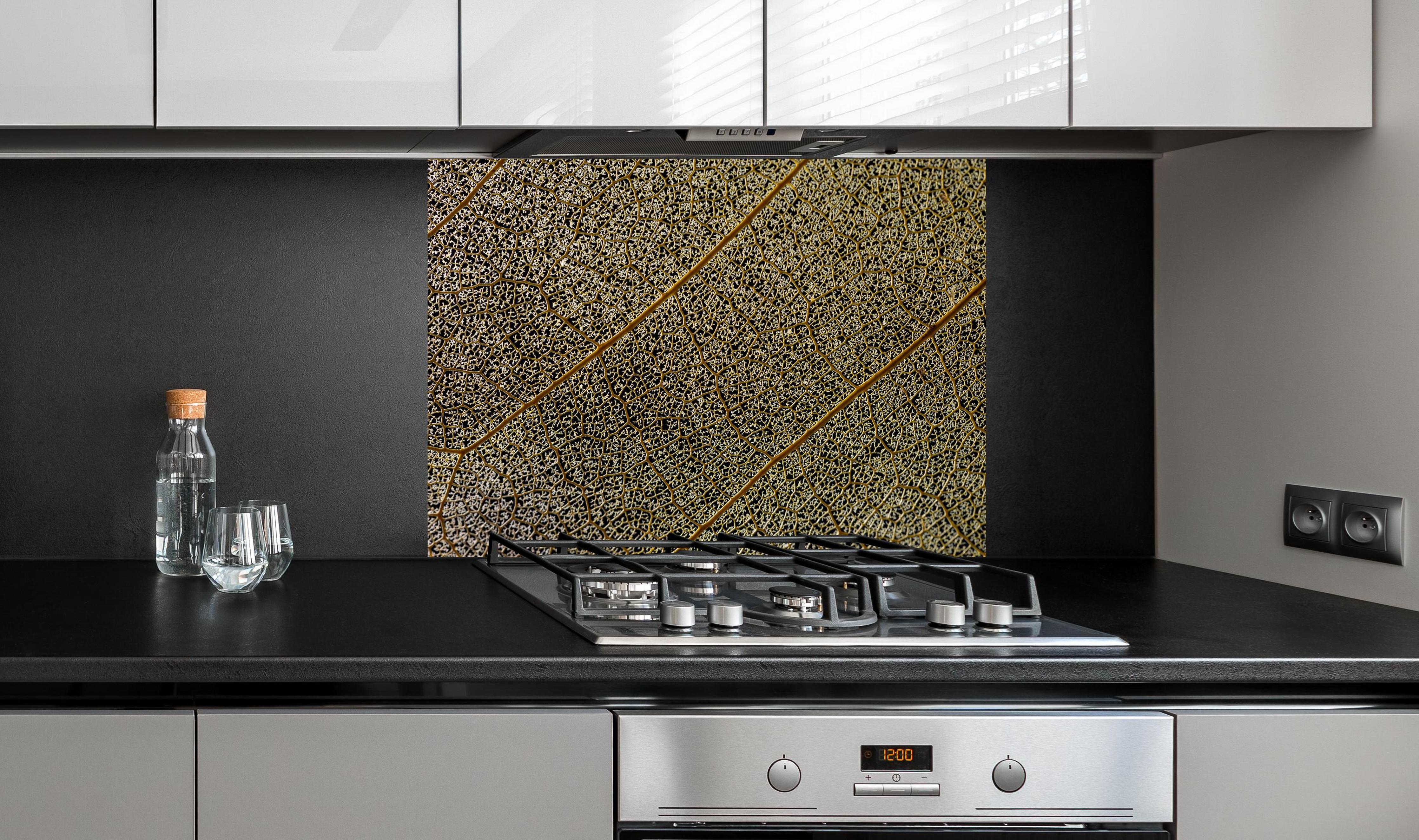 Spritzschutz - Nahaufnahme Blattstruktur mit Adern hinter einem Cerankochfeld zwischen Holz-Kochutensilien