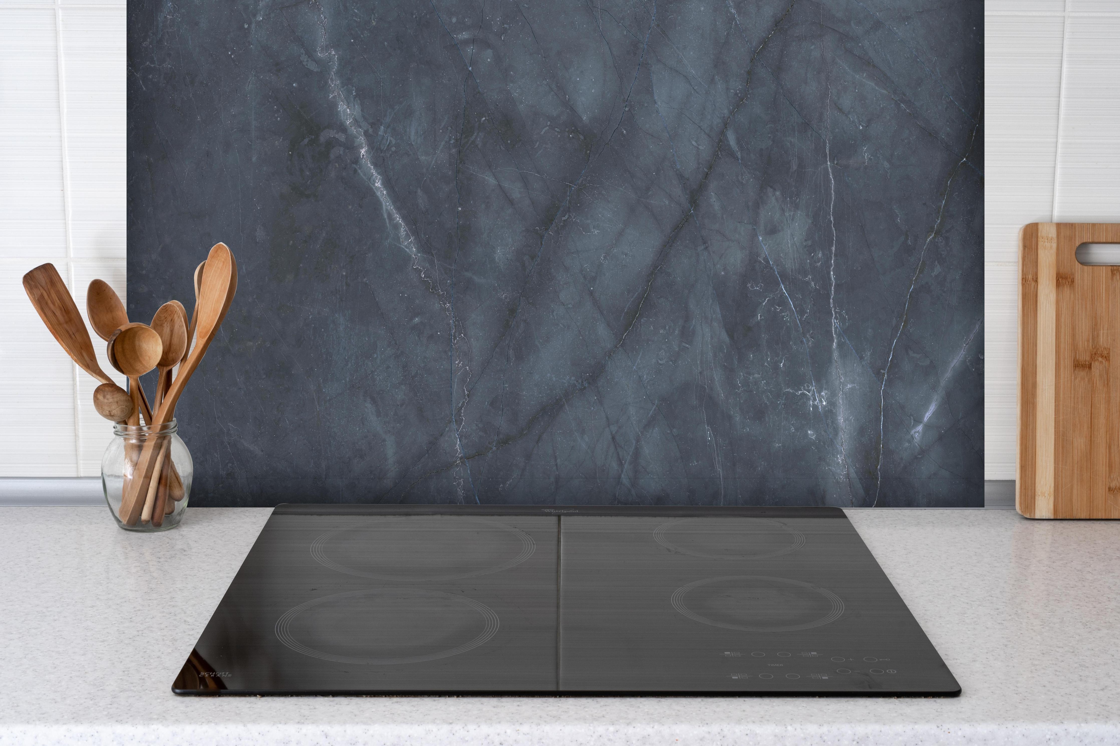 Spritzschutz - Nahaufnahme italienische Marmorplatte hinter einem Cerankochfeld zwischen Holz-Kochutensilien
