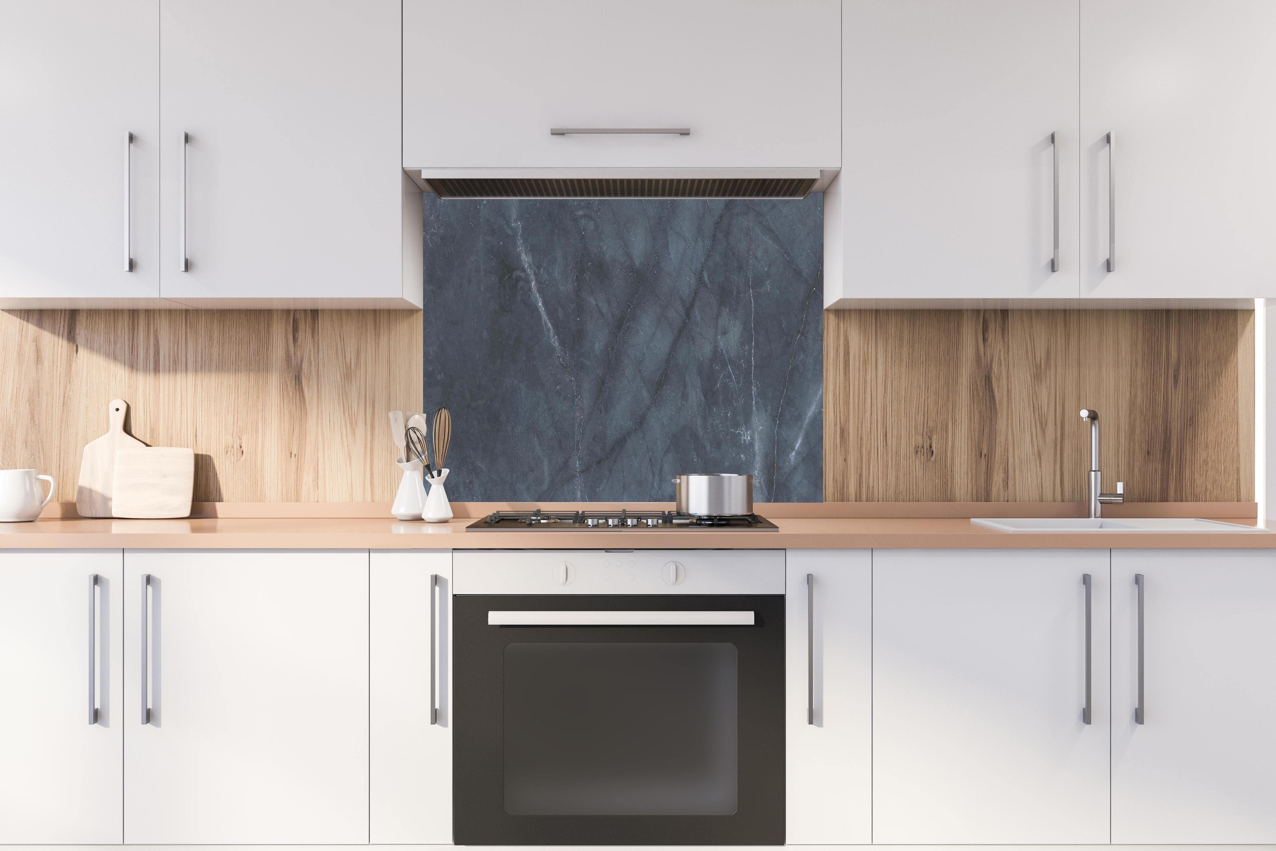 Spritzschutz - Nahaufnahme italienische Marmorplatte hinter einem Cerankochfeld zwischen Holz-Kochutensilien