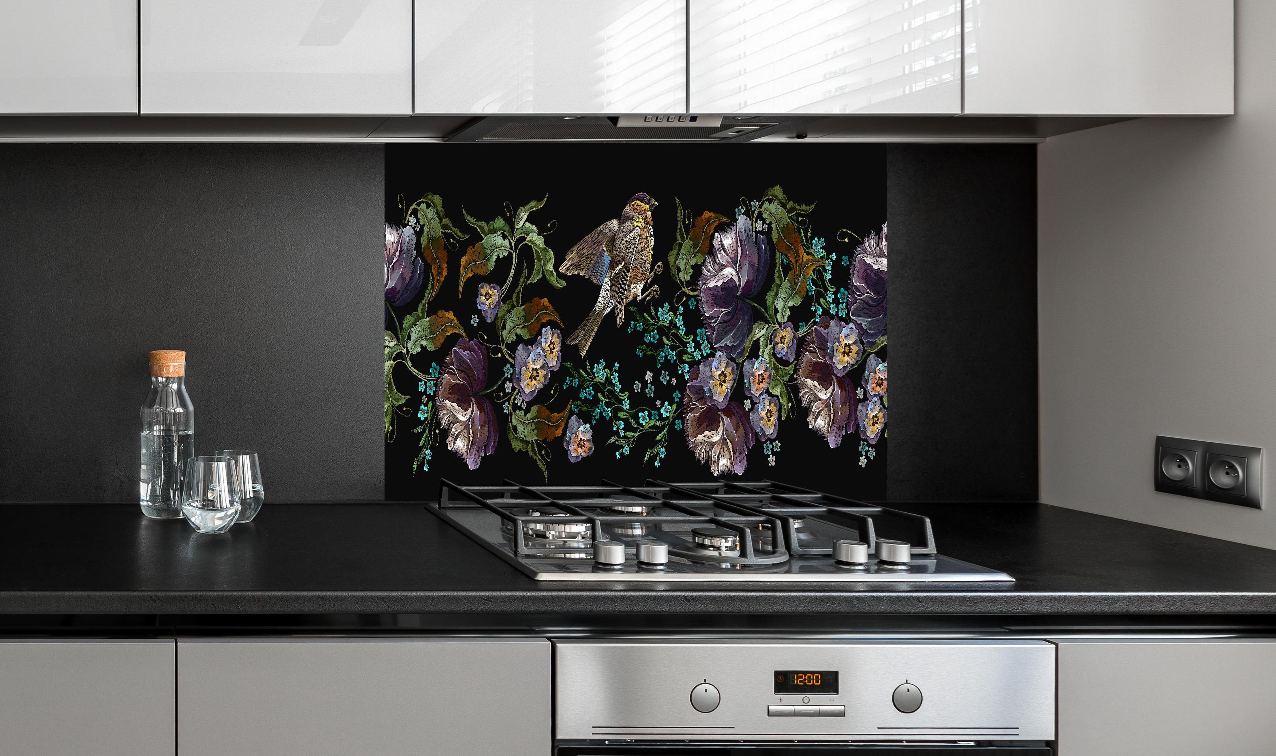 Spritzschutz - Nahtloses Blumen-Vogel-Stickerei-Muster hinter einem Cerankochfeld zwischen Holz-Kochutensilien