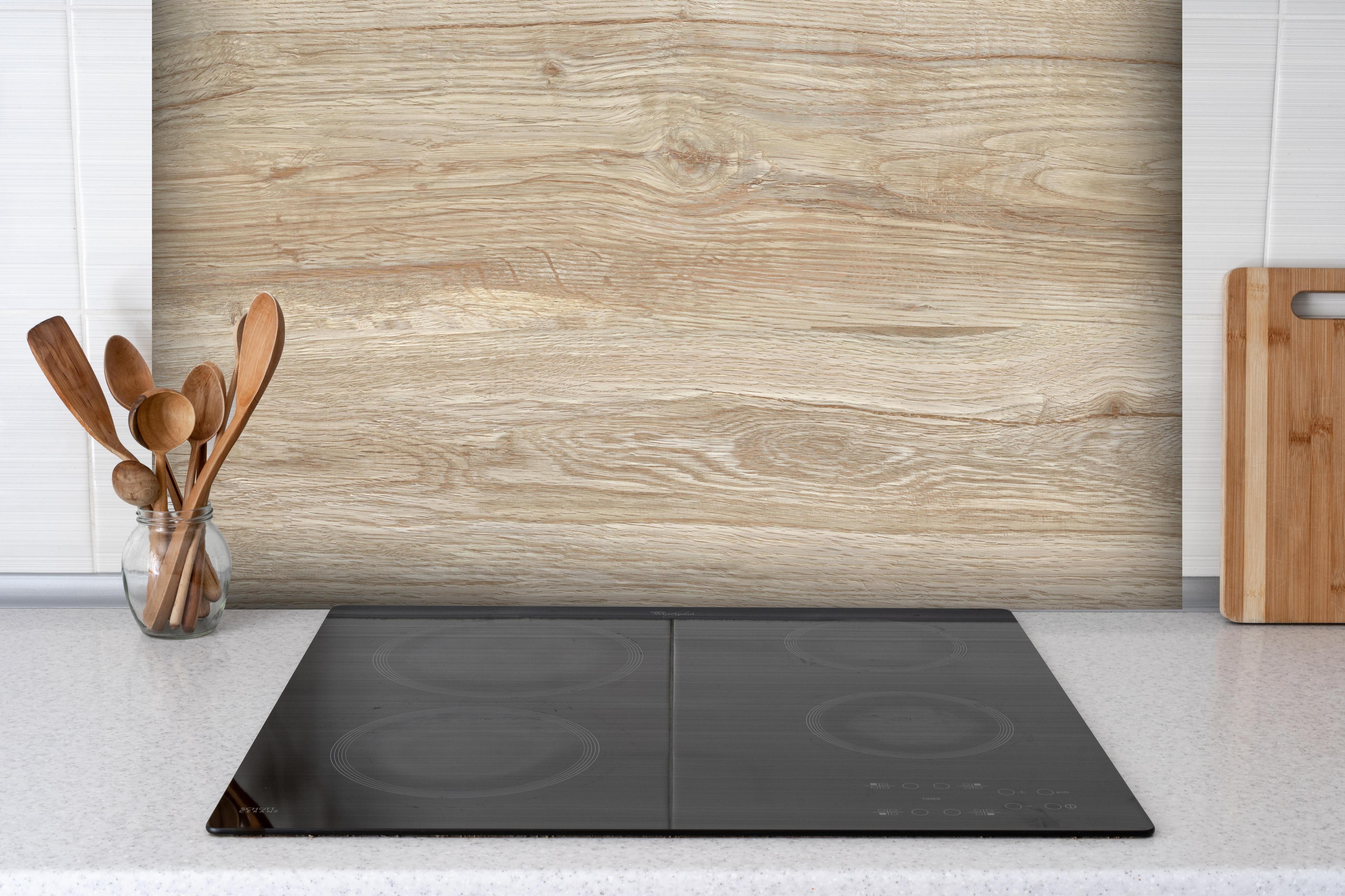 Spritzschutz - Natürliche Holztextur Hintergrund hinter einem Cerankochfeld zwischen Holz-Kochutensilien