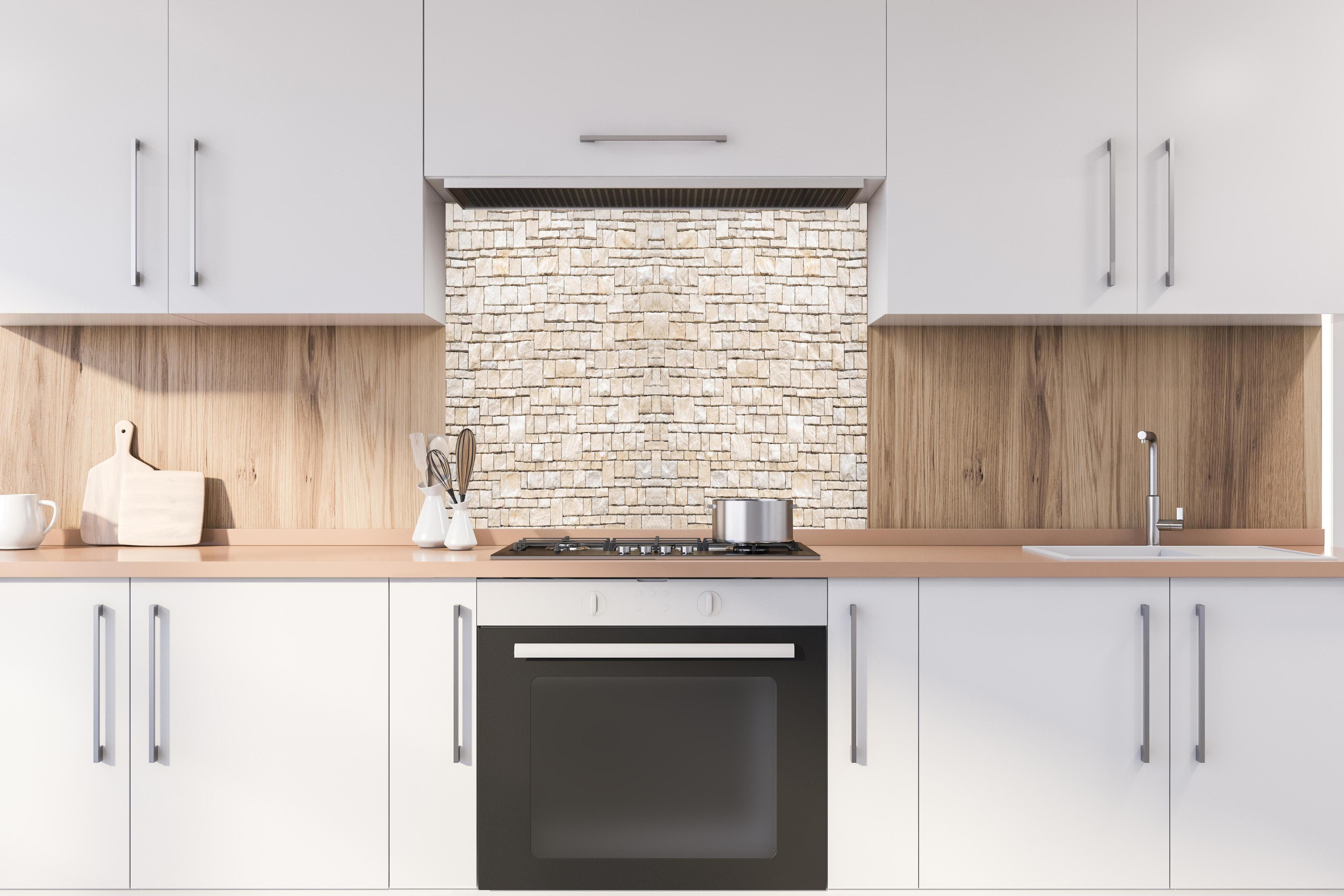 Spritzschutz - Natürliche beige Ziegelwand hinter einem Cerankochfeld zwischen Holz-Kochutensilien