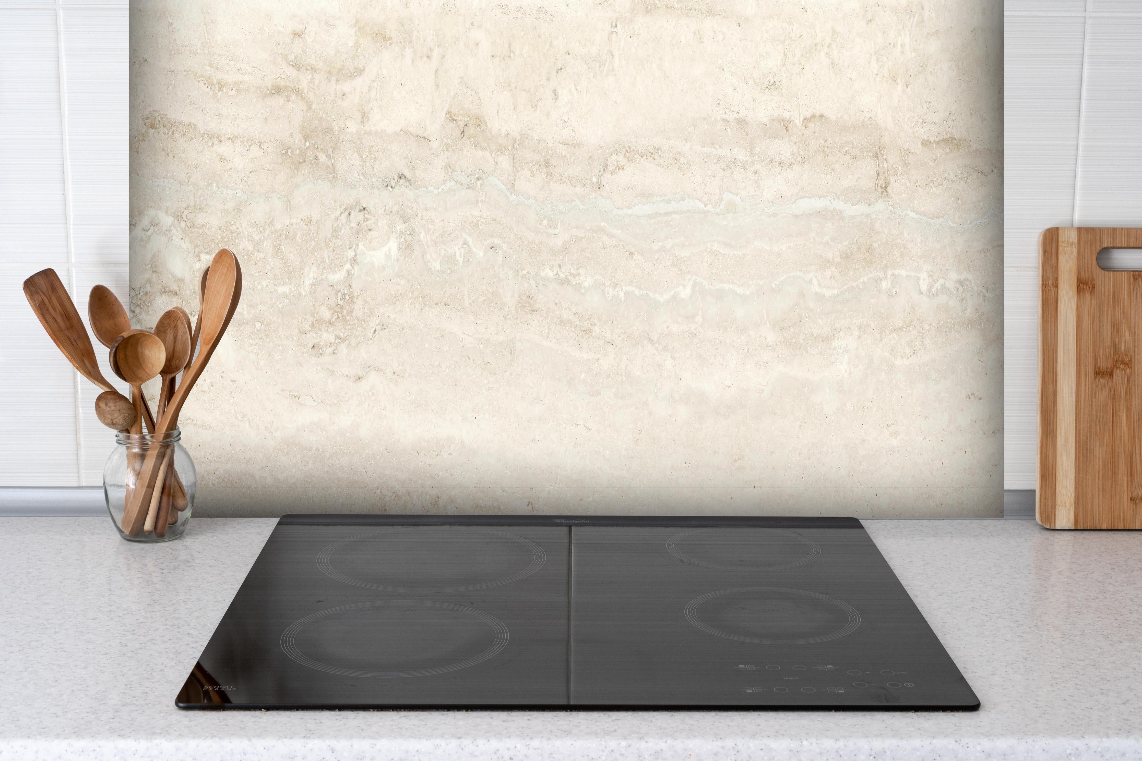 Spritzschutz - Natürlicher Travertin-Stein hinter einem Cerankochfeld zwischen Holz-Kochutensilien