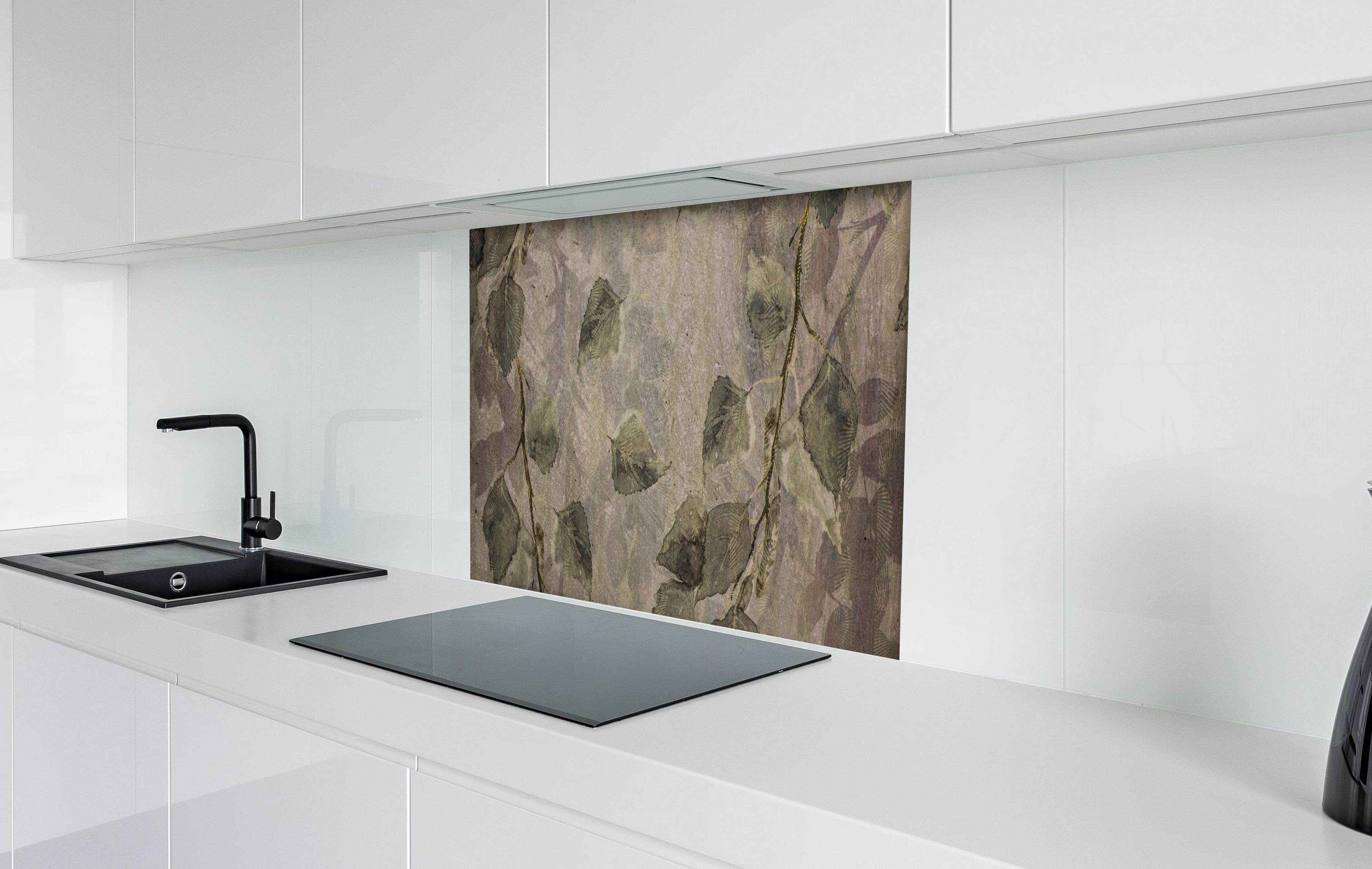 Spritzschutz - Natürliches Blattmuster auf grauen Fliesen hinter einem Cerankochfeld zwischen Holz-Kochutensilien