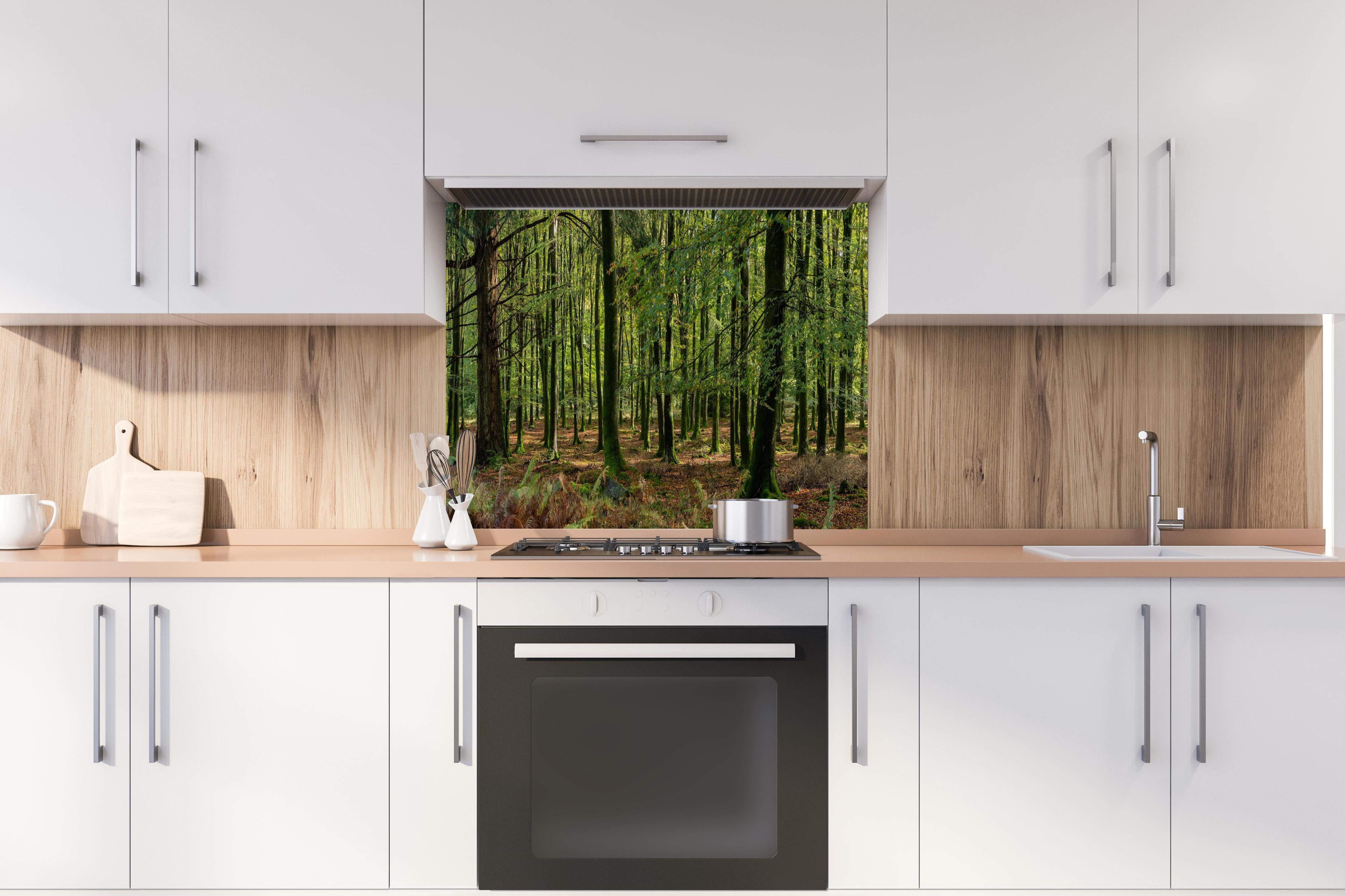 Spritzschutz - Natürliches Waldpanorama in Grün hinter einem Cerankochfeld zwischen Holz-Kochutensilien