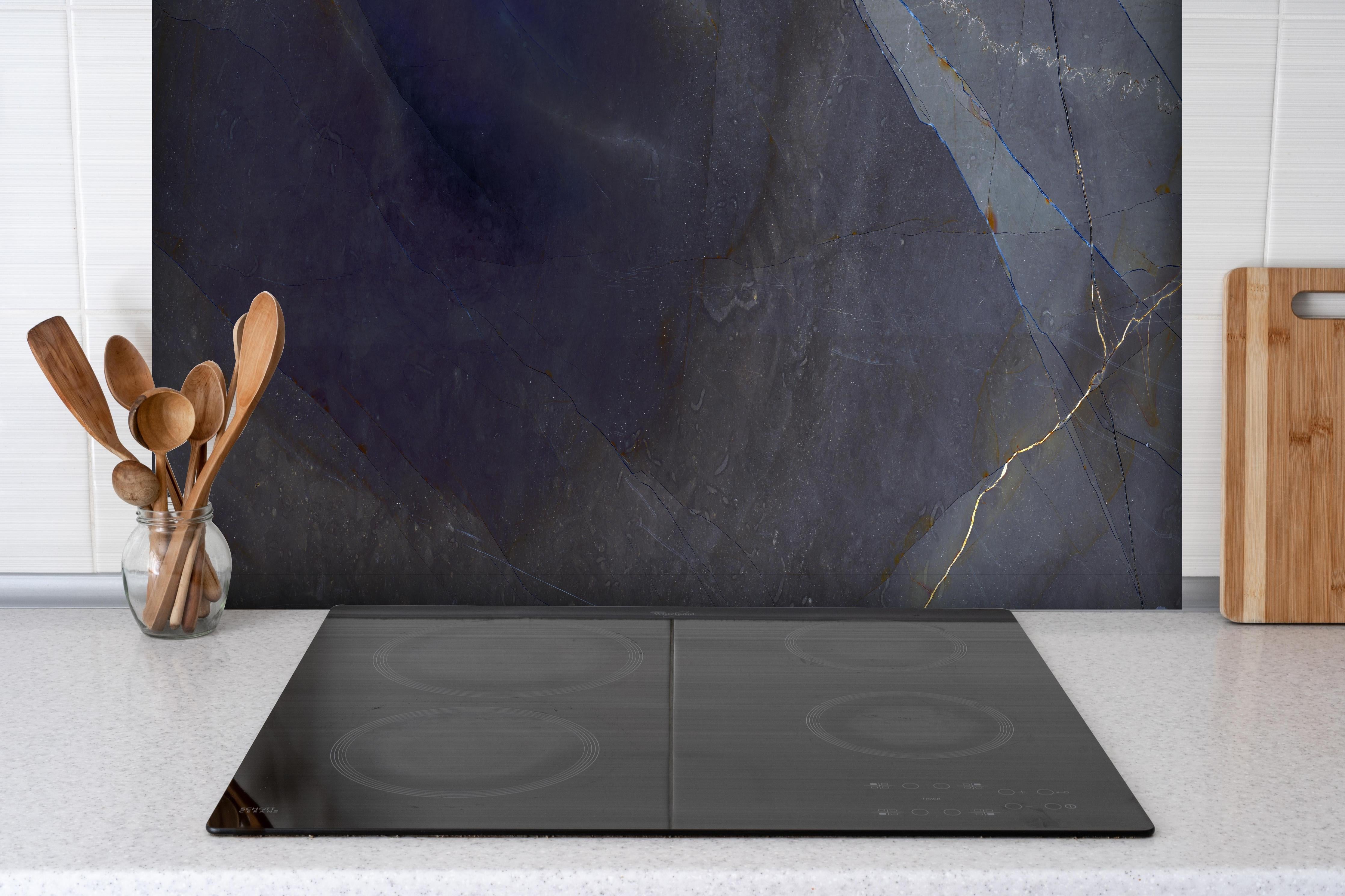 Spritzschutz - Natürliches blaues Marmormuster hinter einem Cerankochfeld zwischen Holz-Kochutensilien