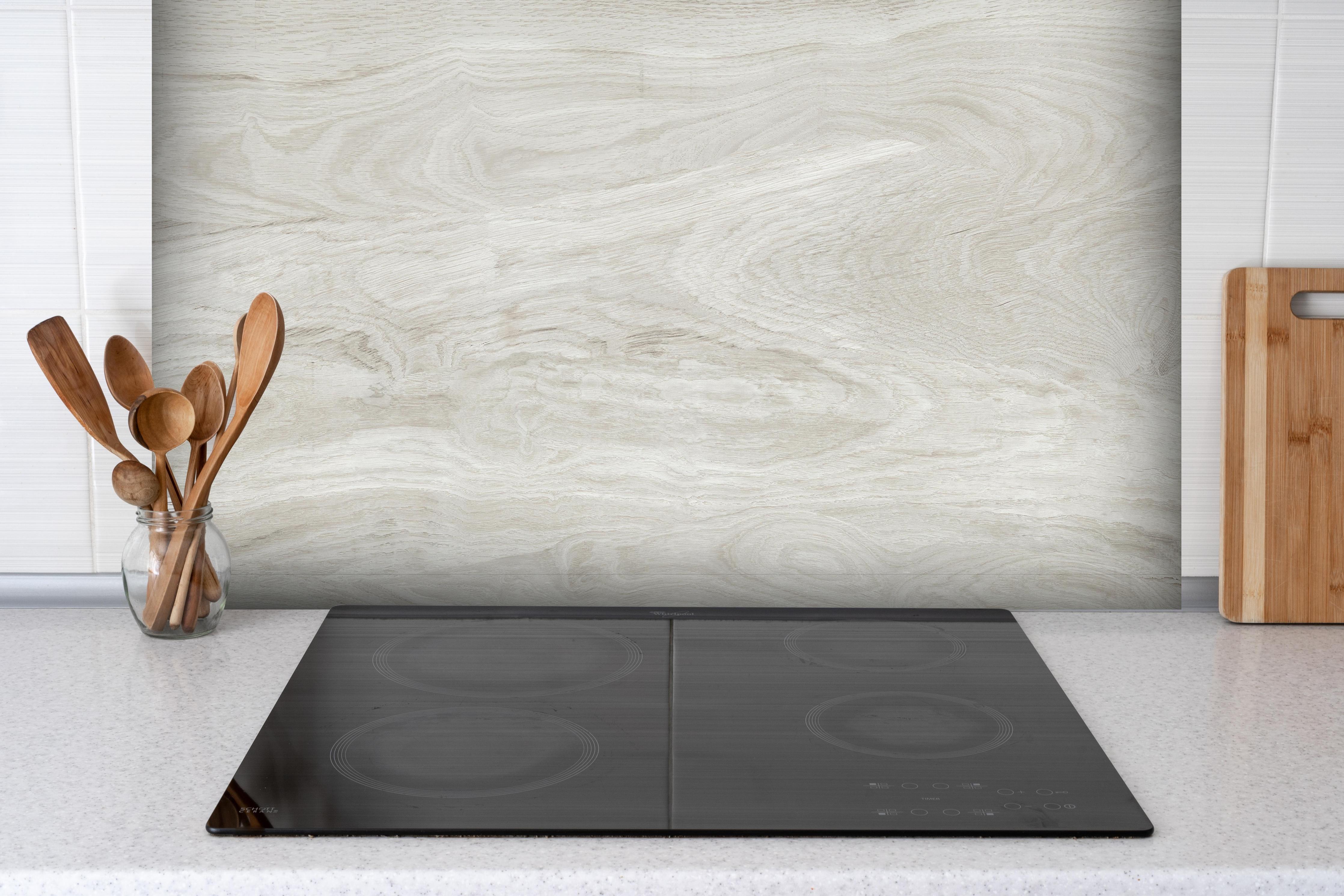 Spritzschutz - Natürliches helles Holzmuster hinter einem Cerankochfeld zwischen Holz-Kochutensilien