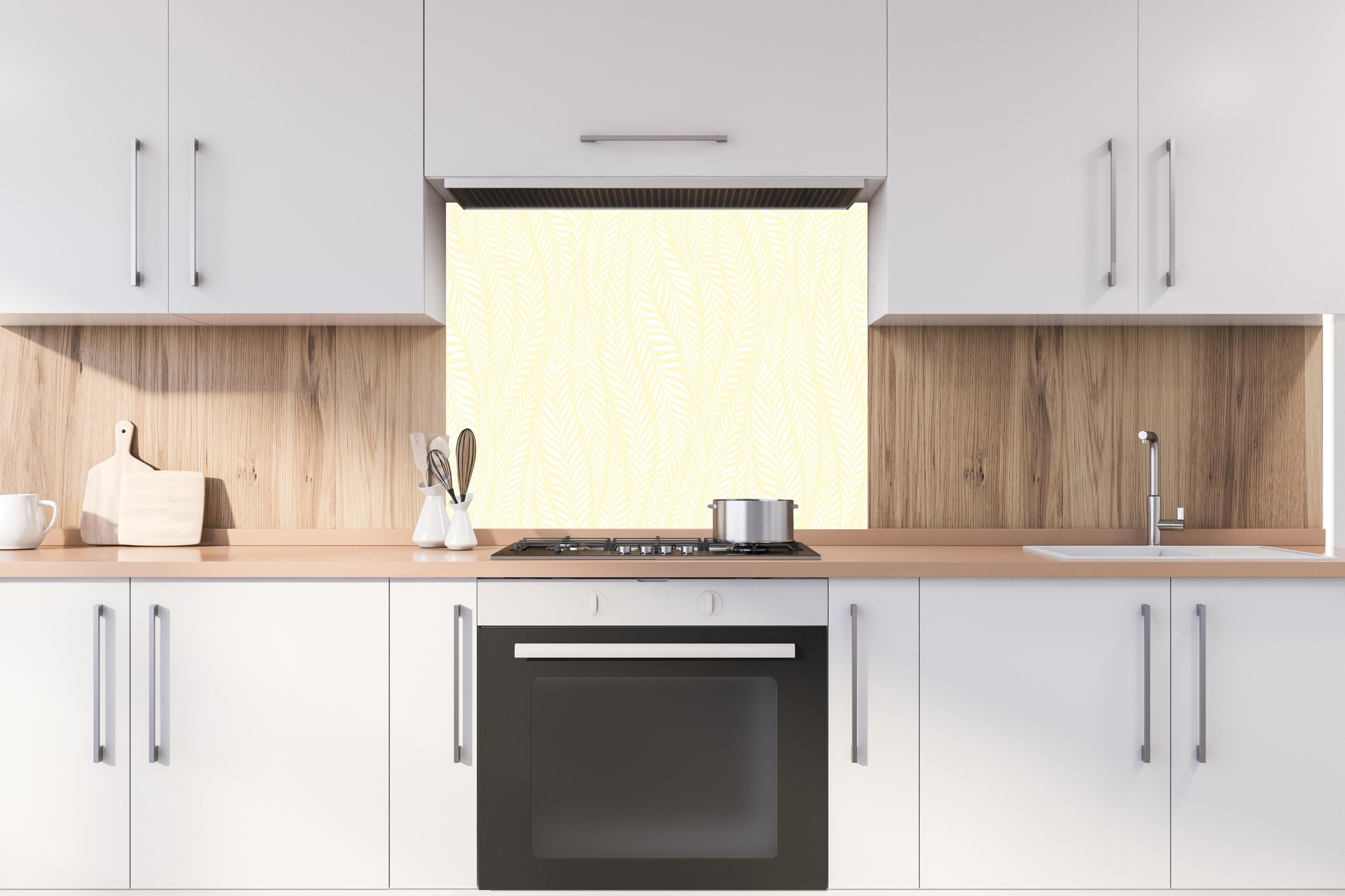 Spritzschutz - Natura Oasi Limone crema hinter einem Cerankochfeld zwischen Holz-Kochutensilien