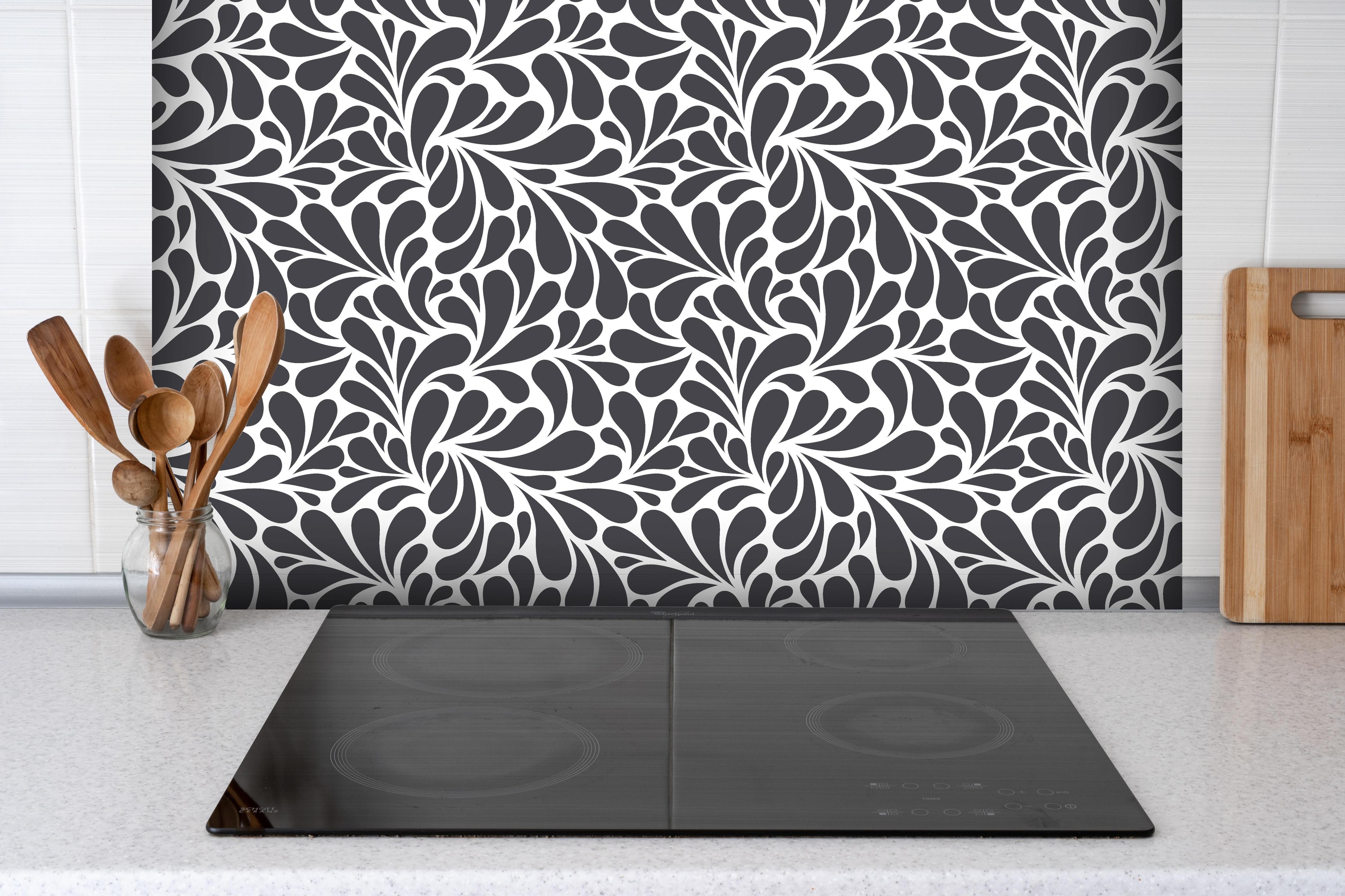 Spritzschutz - Natura Petaloso Antracite hinter einem Cerankochfeld zwischen Holz-Kochutensilien