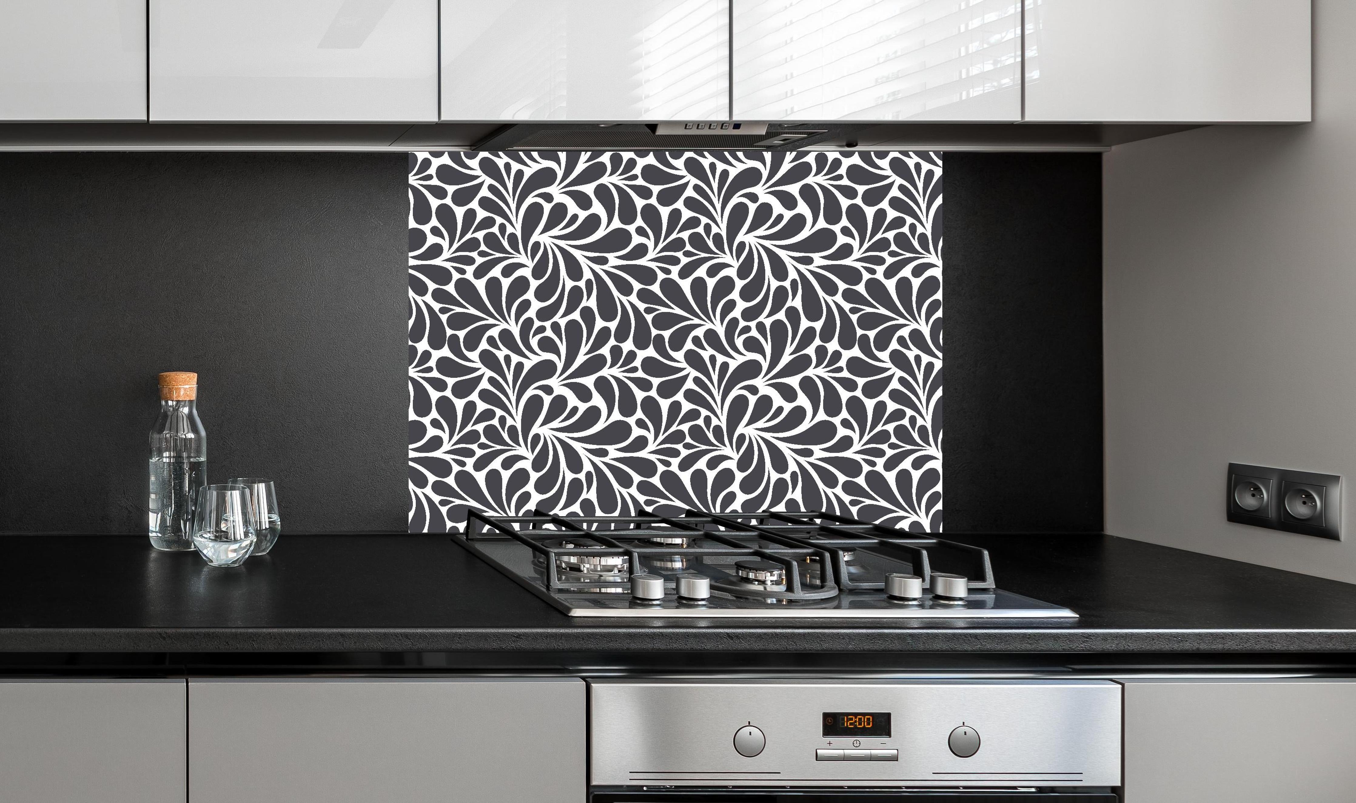 Spritzschutz - Natura Petaloso Antracite hinter einem Cerankochfeld zwischen Holz-Kochutensilien