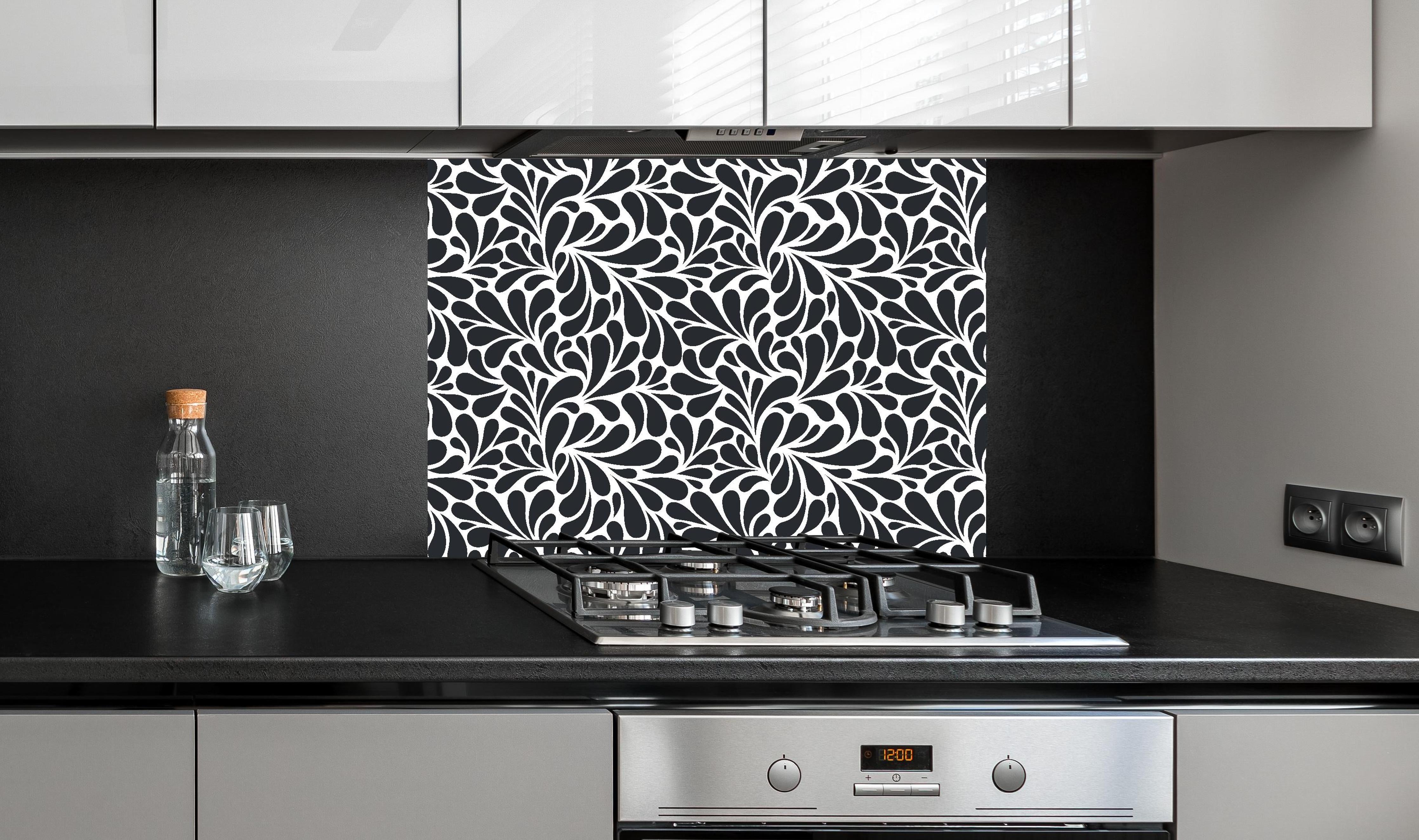 Spritzschutz - Natura Petaloso Carbone hinter einem Cerankochfeld zwischen Holz-Kochutensilien