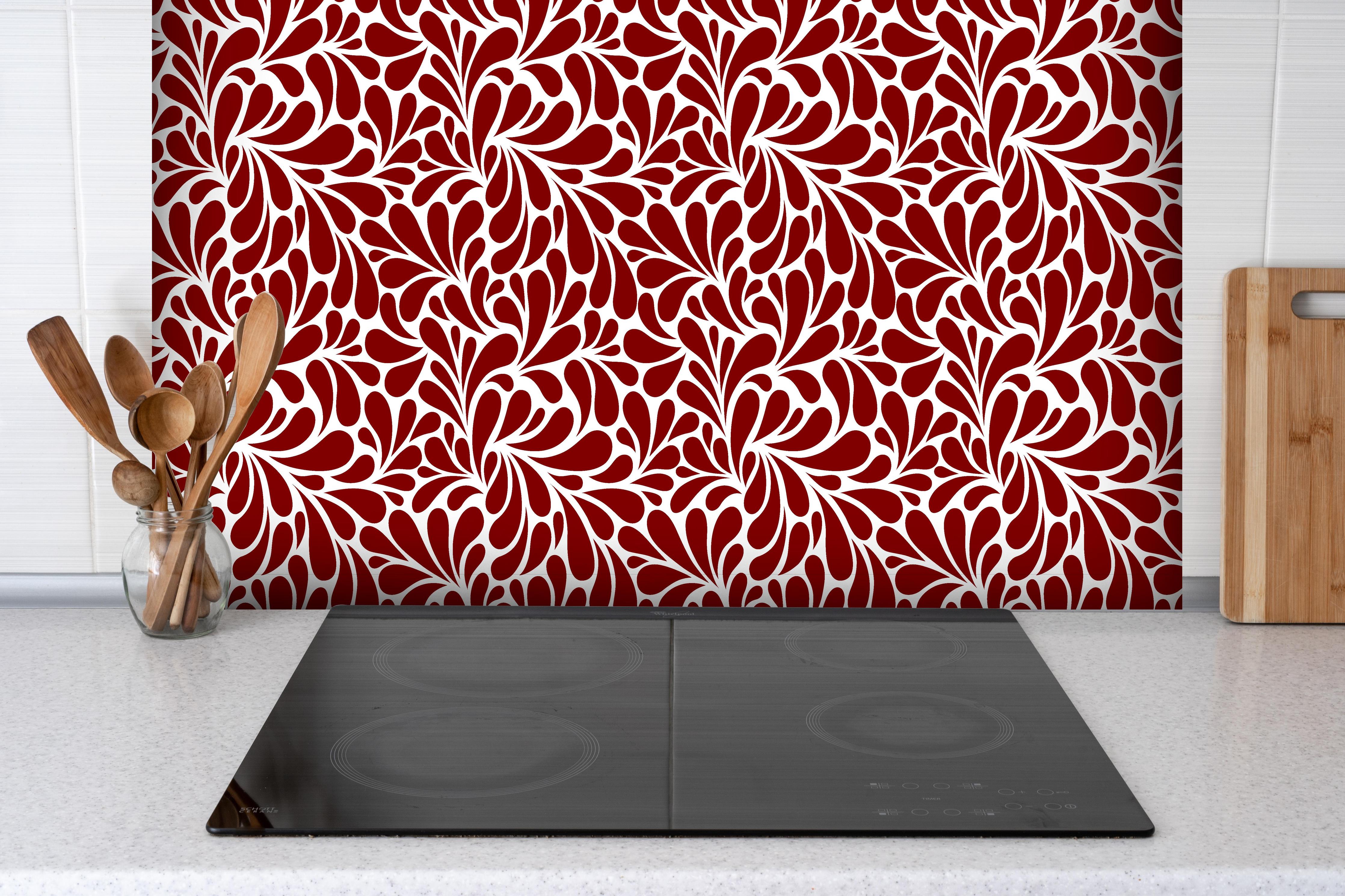 Spritzschutz - Natura Petaloso Granata hinter einem Cerankochfeld zwischen Holz-Kochutensilien