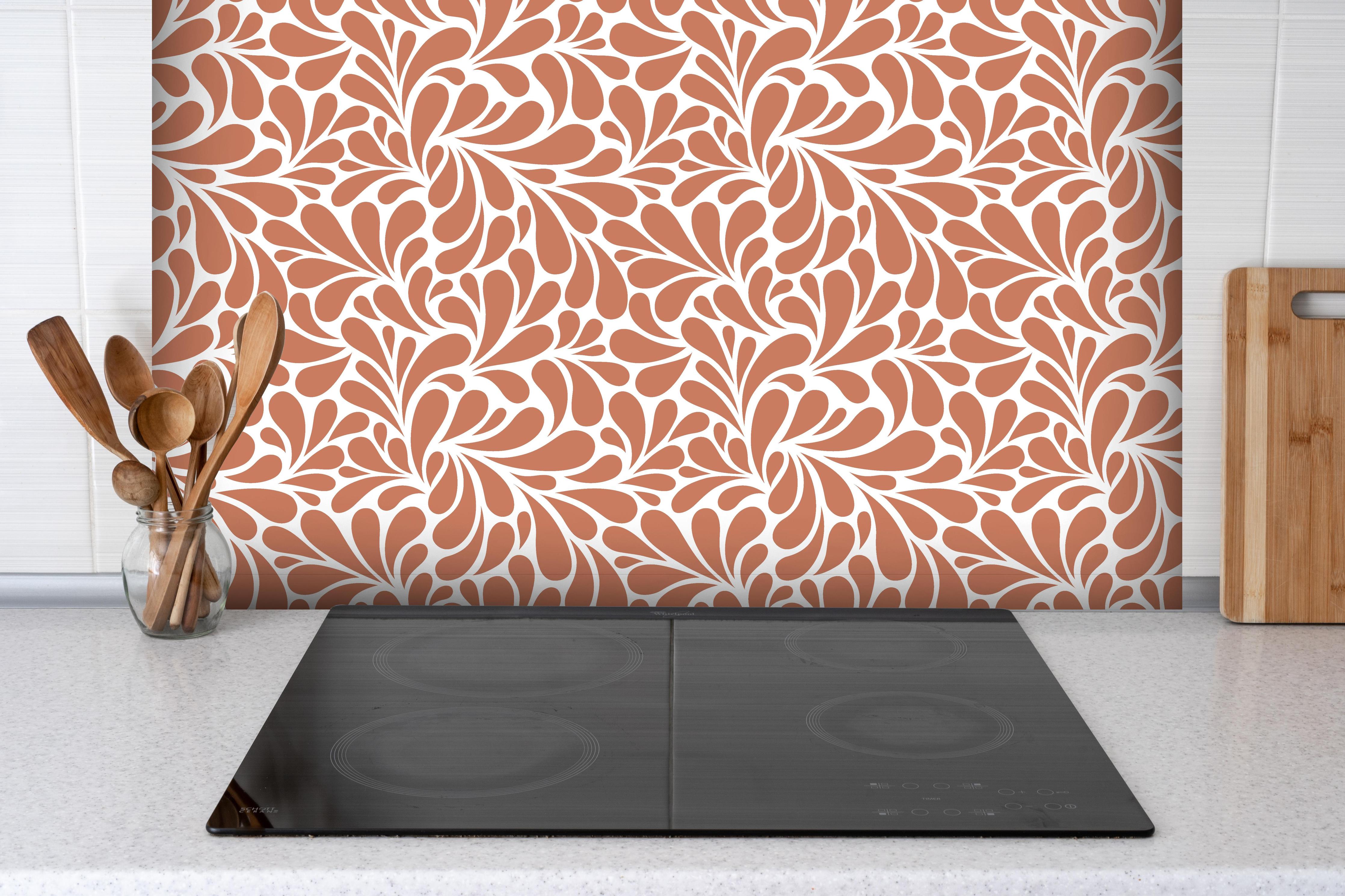 Spritzschutz - Natura Petaloso Terracotta hinter einem Cerankochfeld zwischen Holz-Kochutensilien