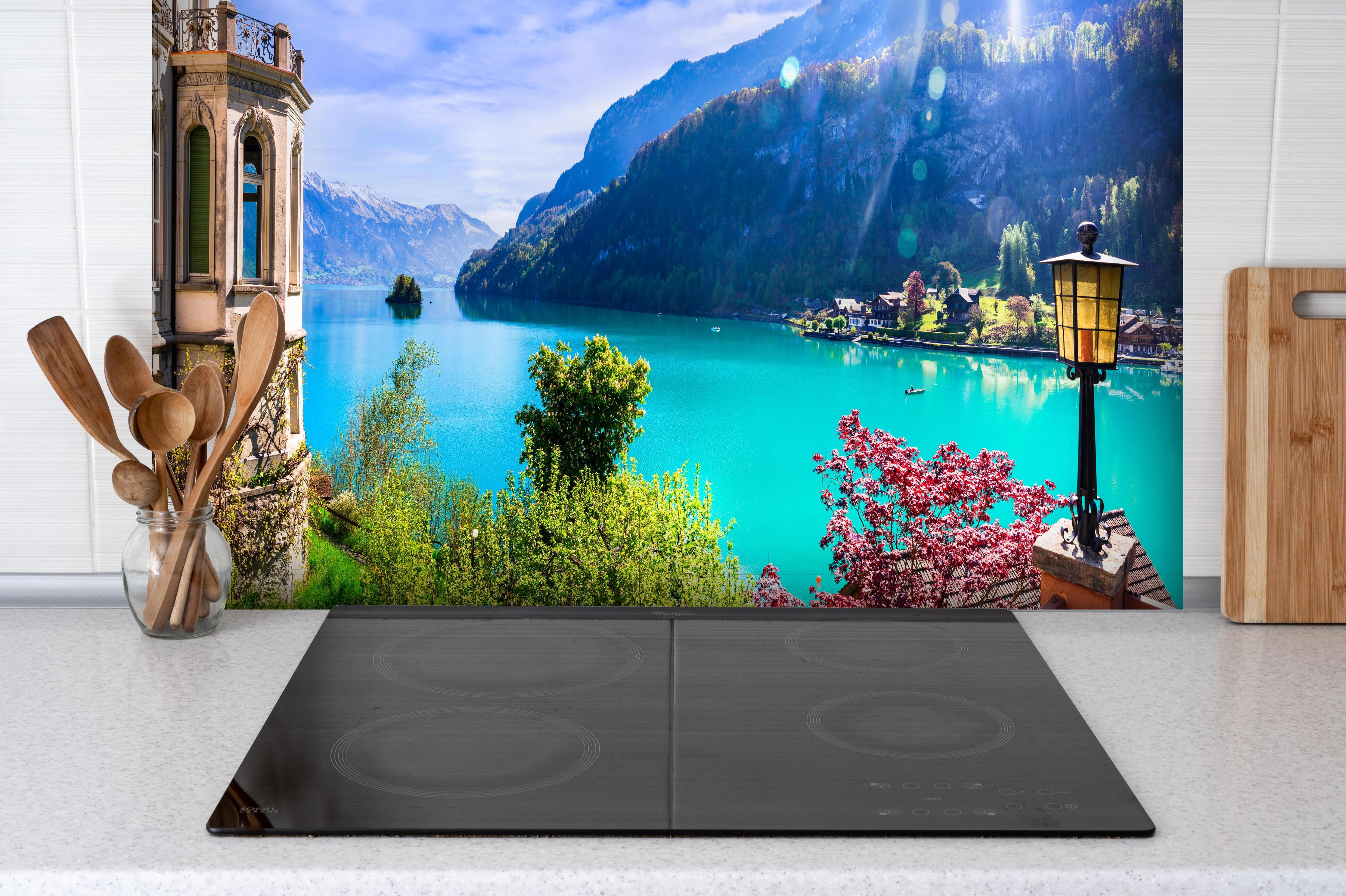 Spritzschutz - Naturkulisse des Brienzersees - Schweiz hinter einem Cerankochfeld zwischen Holz-Kochutensilien