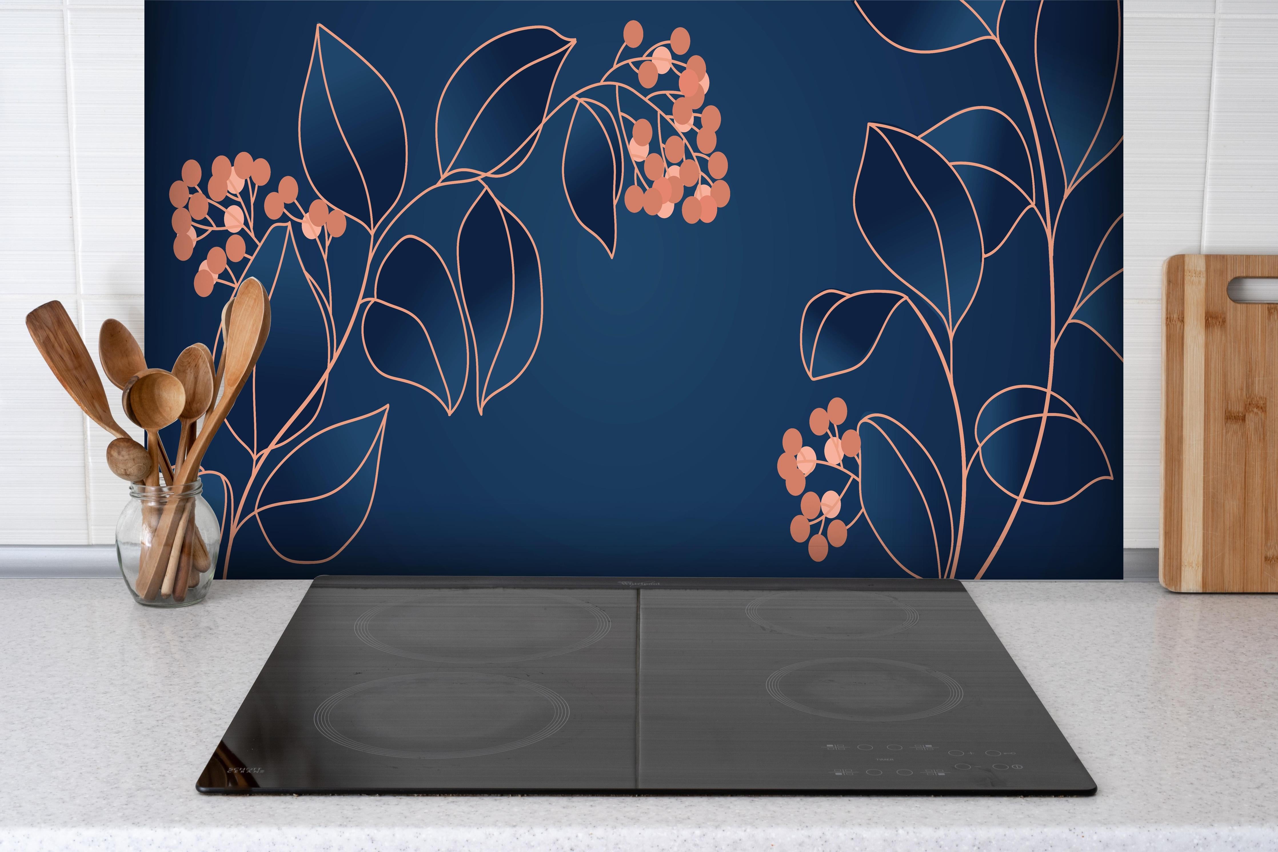 Spritzschutz - Navyblaues Leinwandbild mit orangen Blüten hinter einem Cerankochfeld zwischen Holz-Kochutensilien