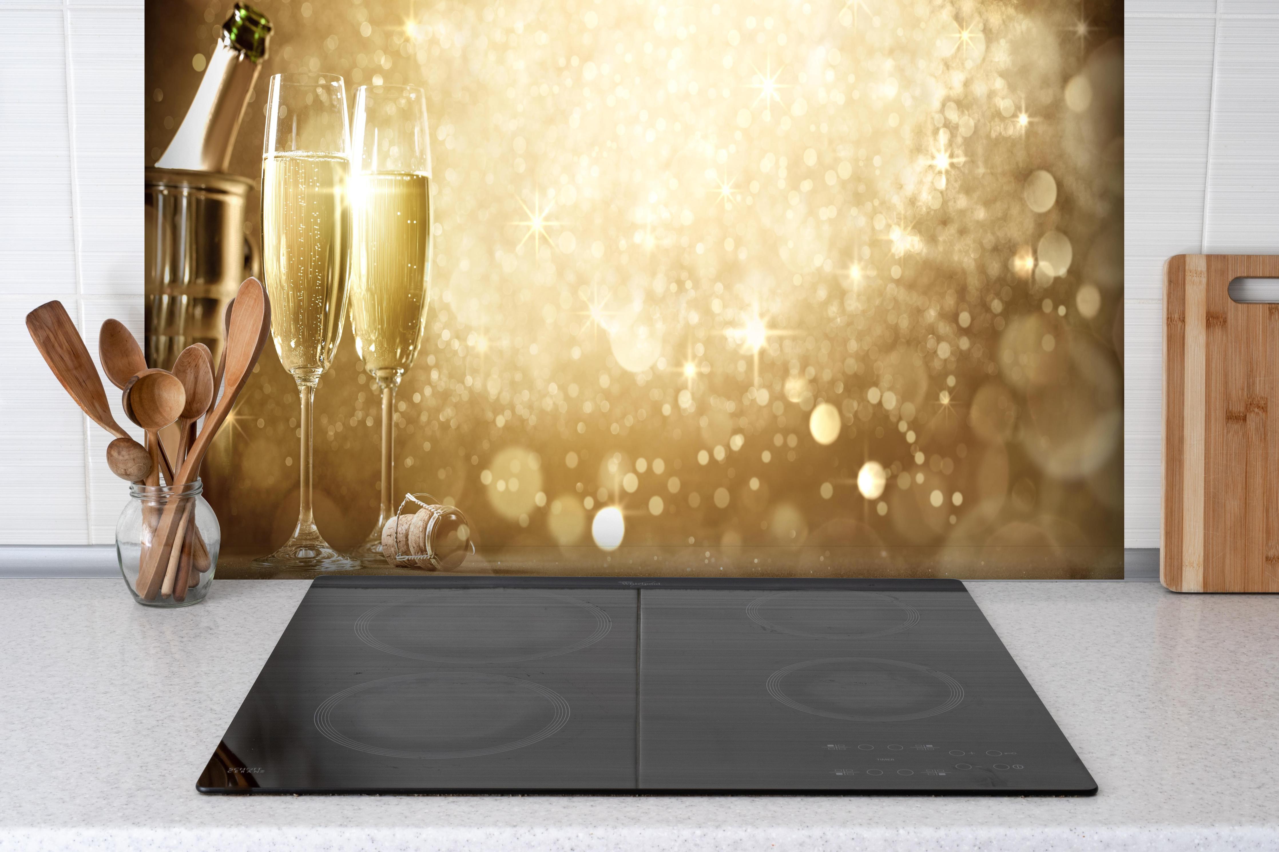 Spritzschutz - Neujahrsfeier hinter einem Cerankochfeld zwischen Holz-Kochutensilien