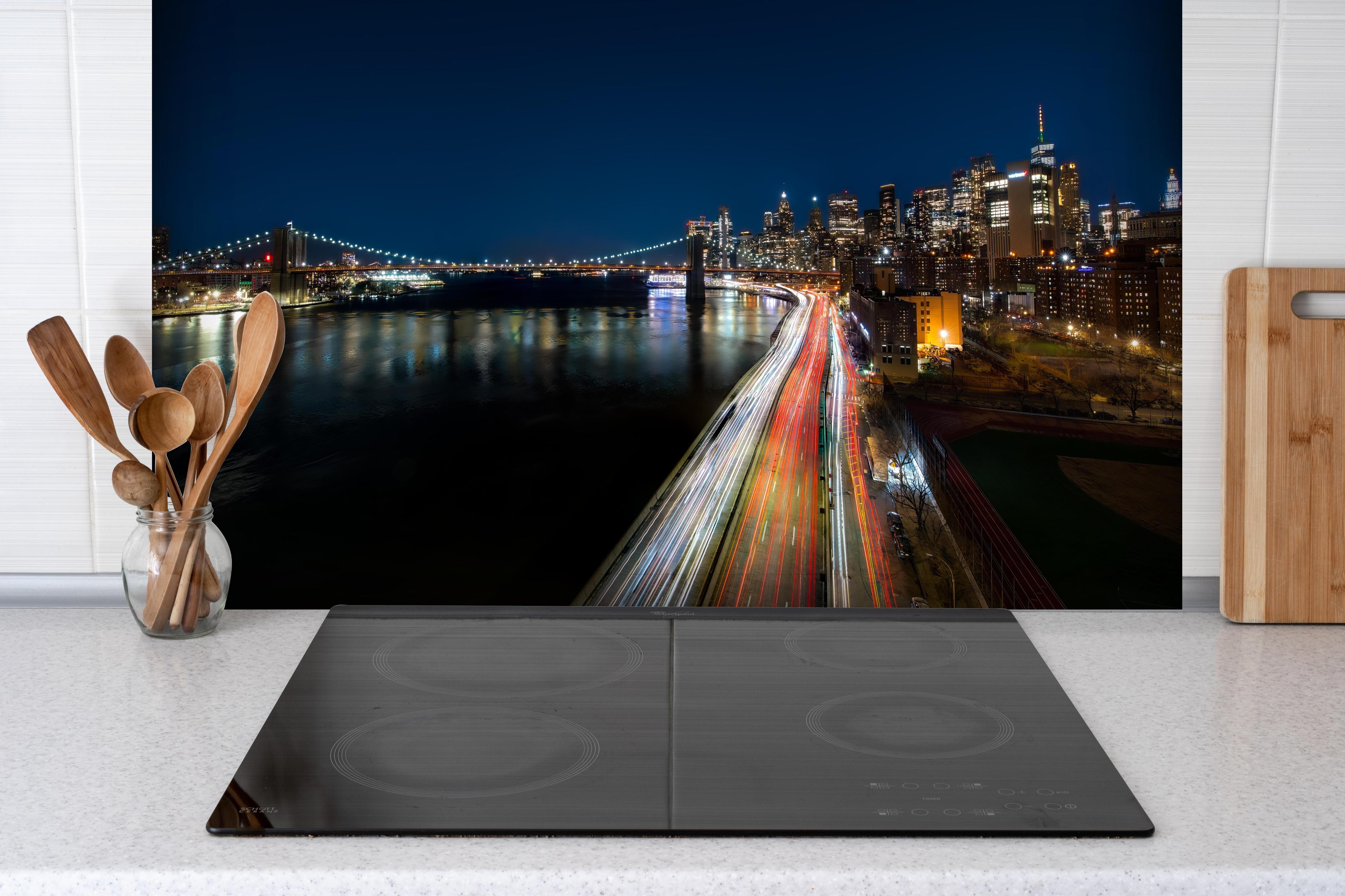 Spritzschutz - New York Light Night hinter einem Cerankochfeld zwischen Holz-Kochutensilien