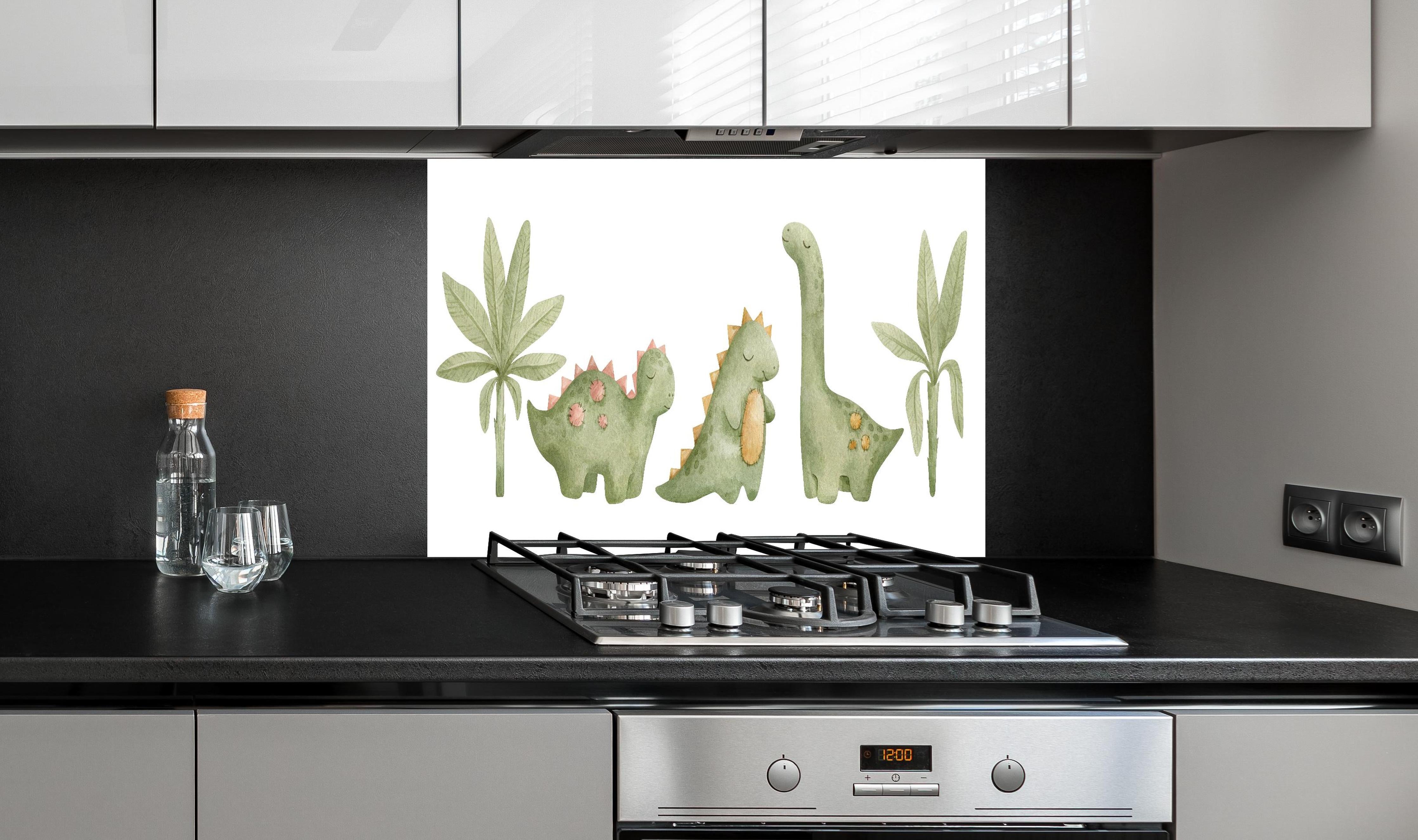 Spritzschutz - Niedliche Dinosaurier hinter einem Cerankochfeld zwischen Holz-Kochutensilien