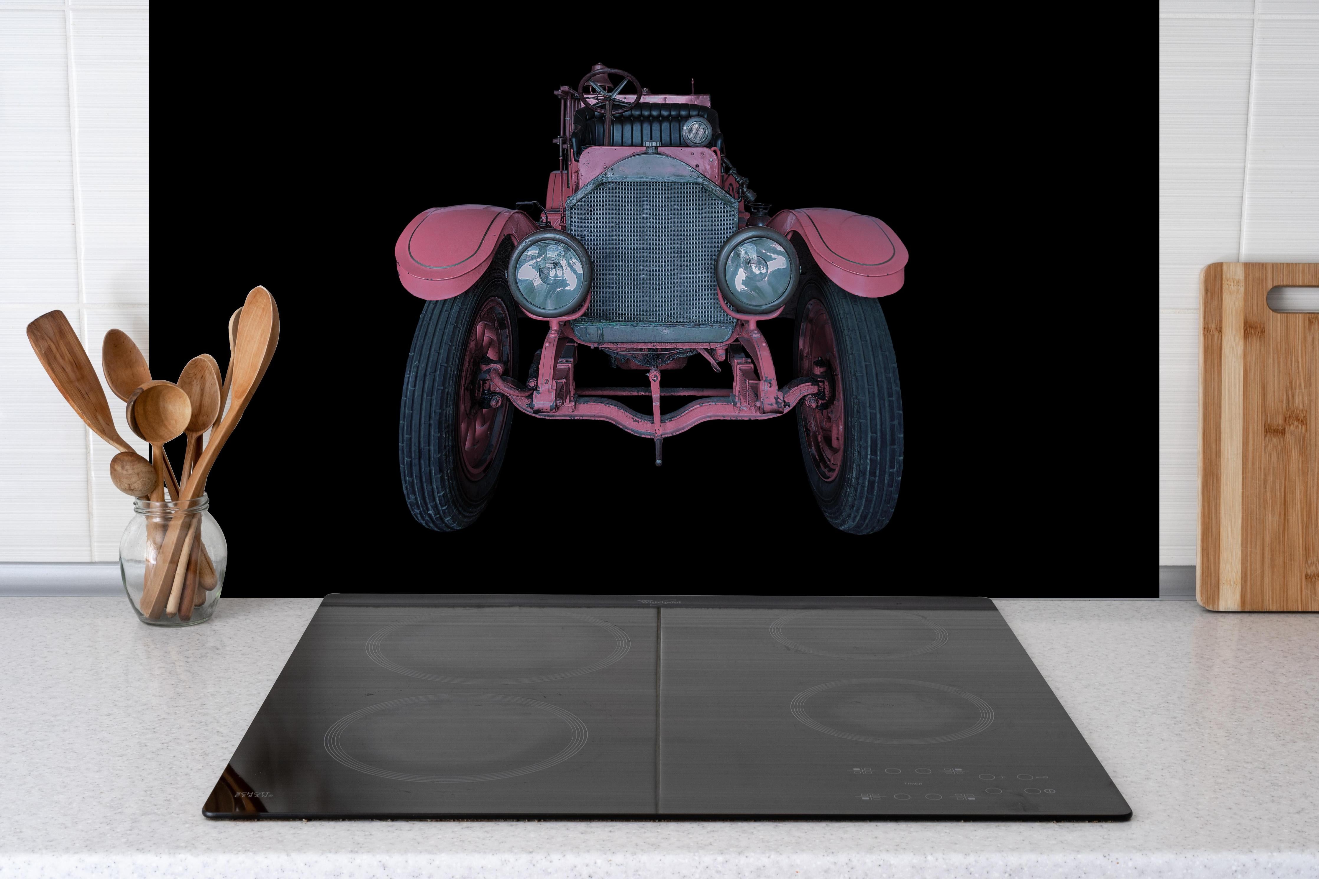 Spritzschutz - Oldtimer isoliert auf Schwarz hinter einem Cerankochfeld zwischen Holz-Kochutensilien