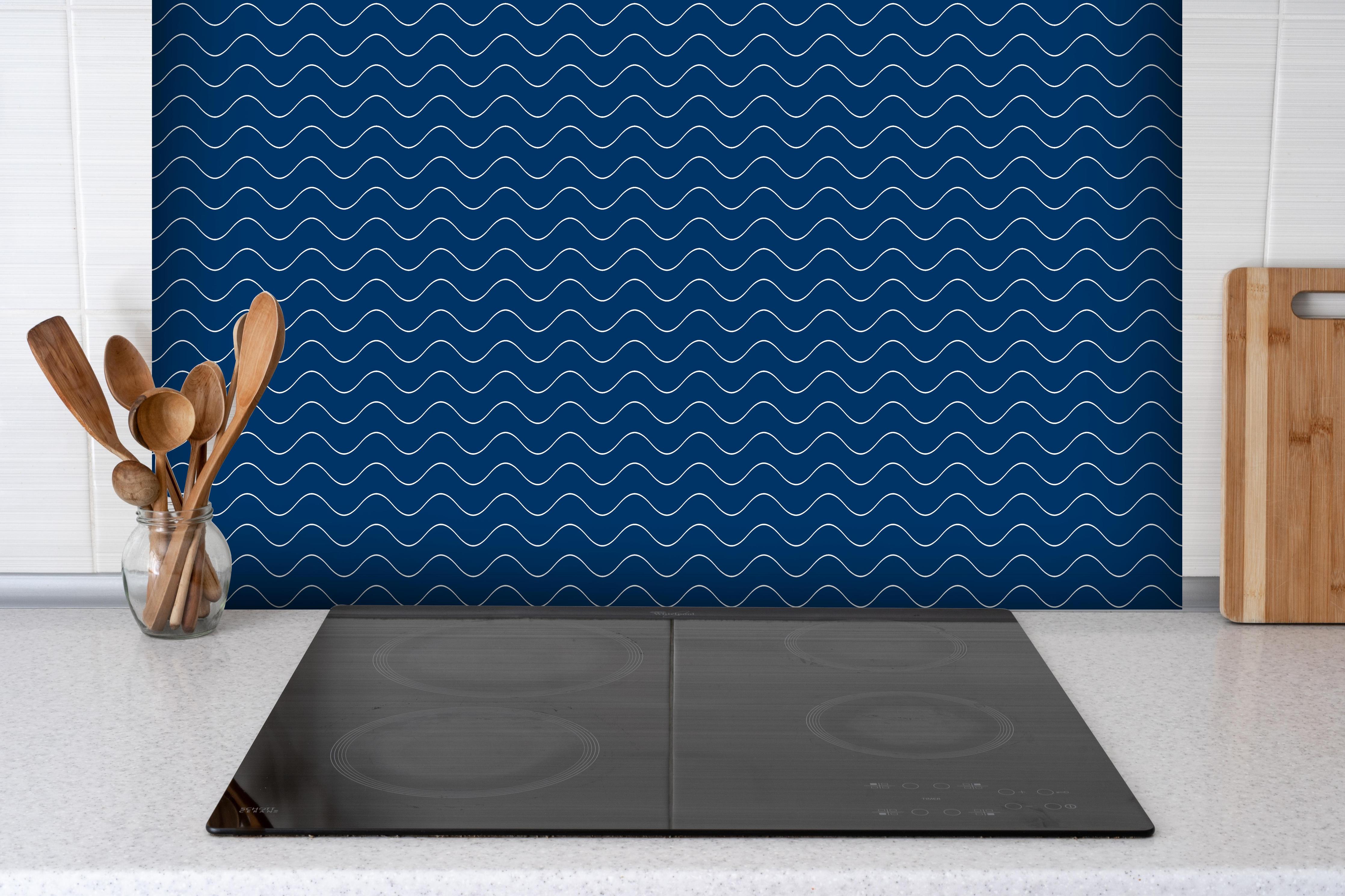 Spritzschutz - Onde Abisso Blu notte hinter einem Cerankochfeld zwischen Holz-Kochutensilien
