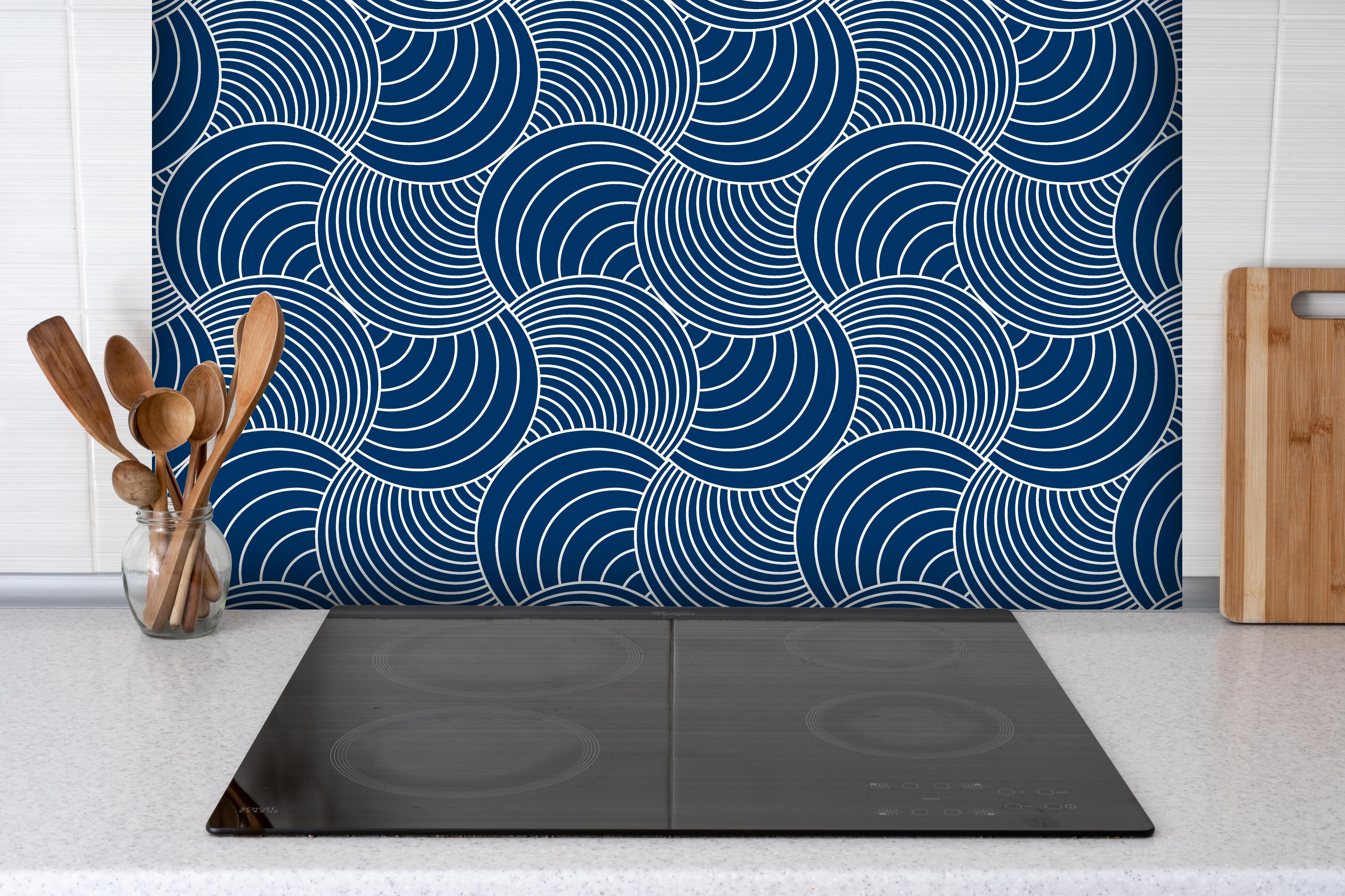 Spritzschutz - Onde Imaginario Blu notte hinter einem Cerankochfeld zwischen Holz-Kochutensilien