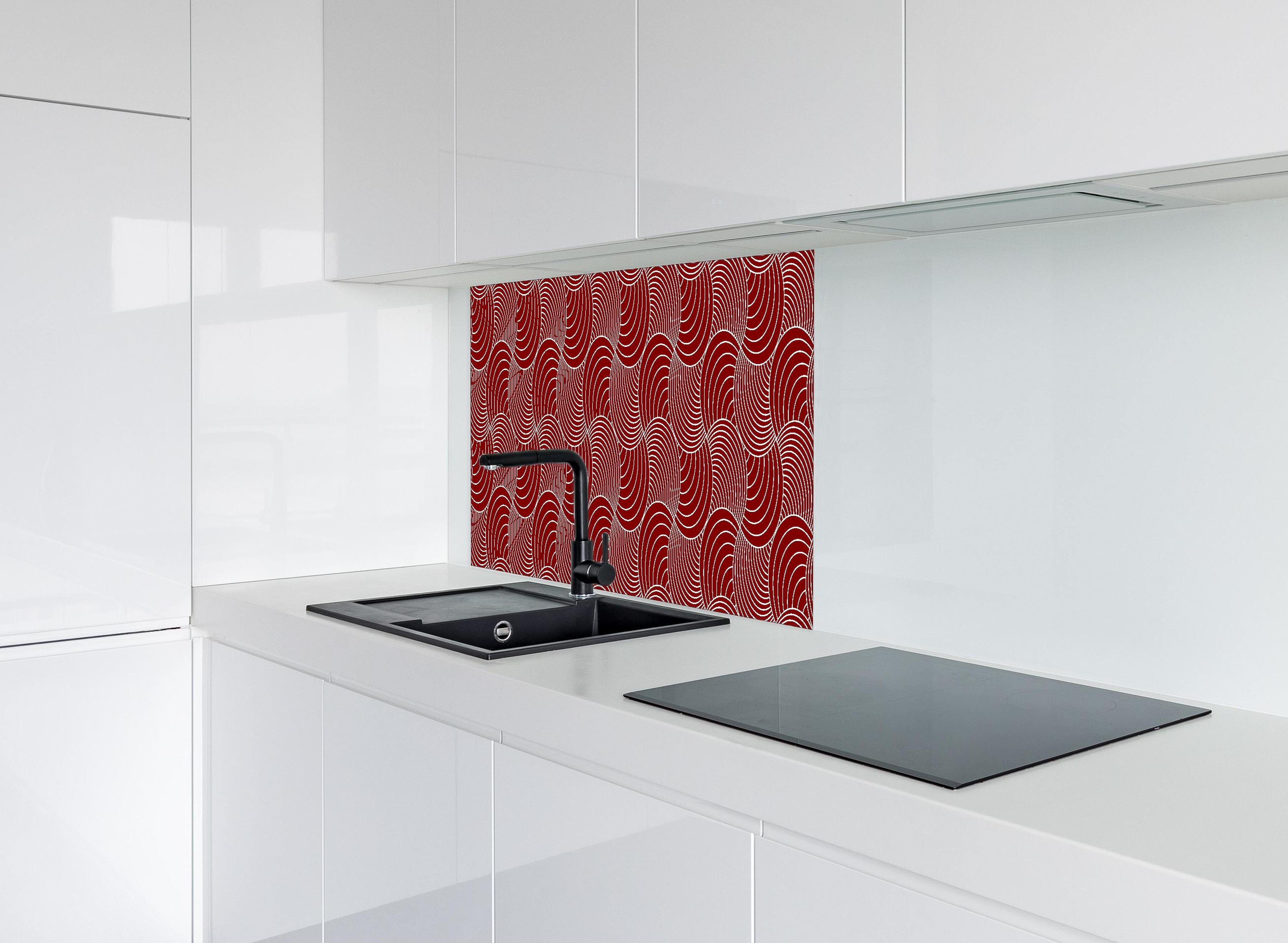 Spritzschutz - Onde Imaginario Granata hinter einem Cerankochfeld zwischen Holz-Kochutensilien