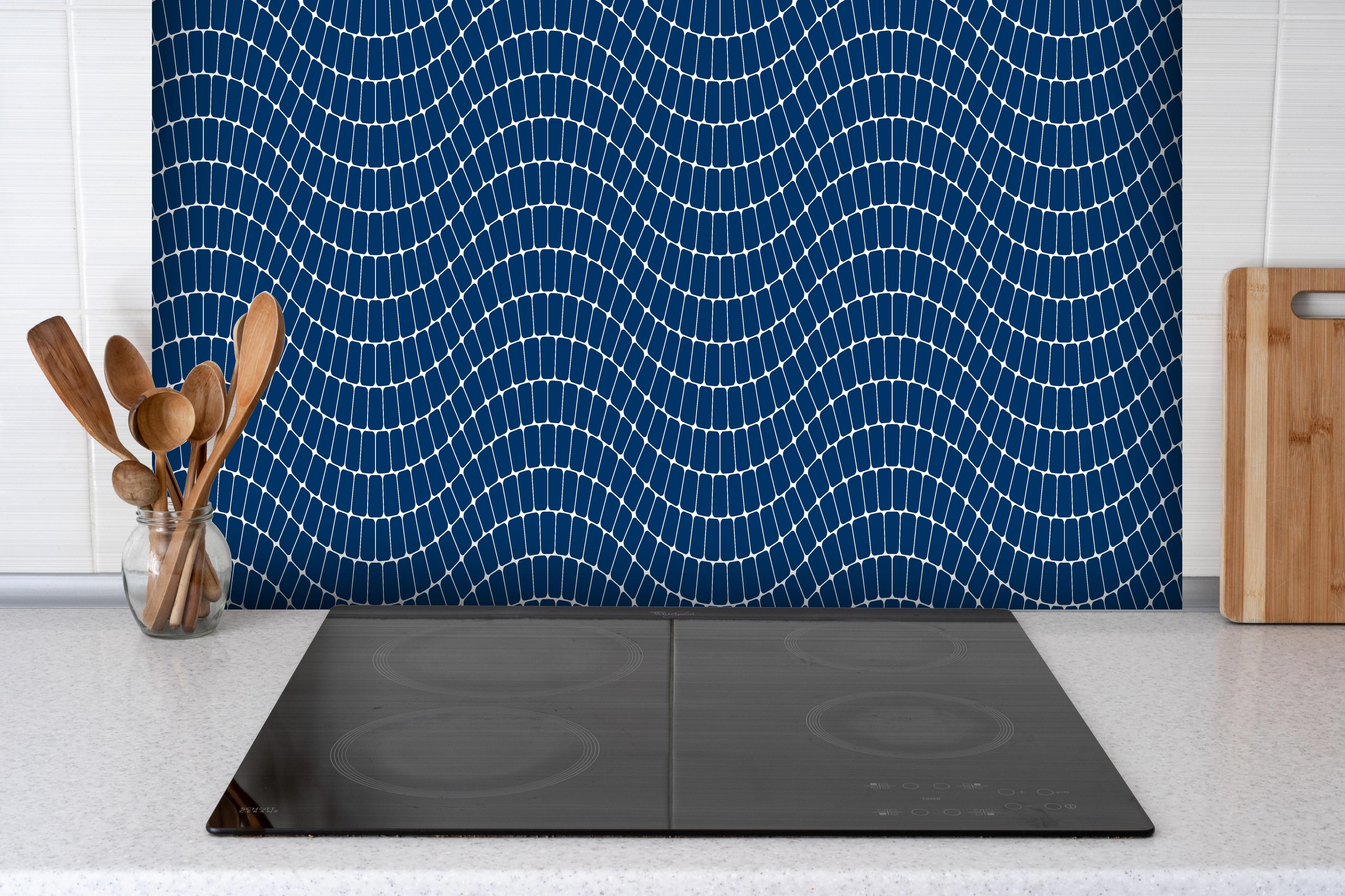 Spritzschutz - Onde Sinuoso Blu notte hinter einem Cerankochfeld zwischen Holz-Kochutensilien