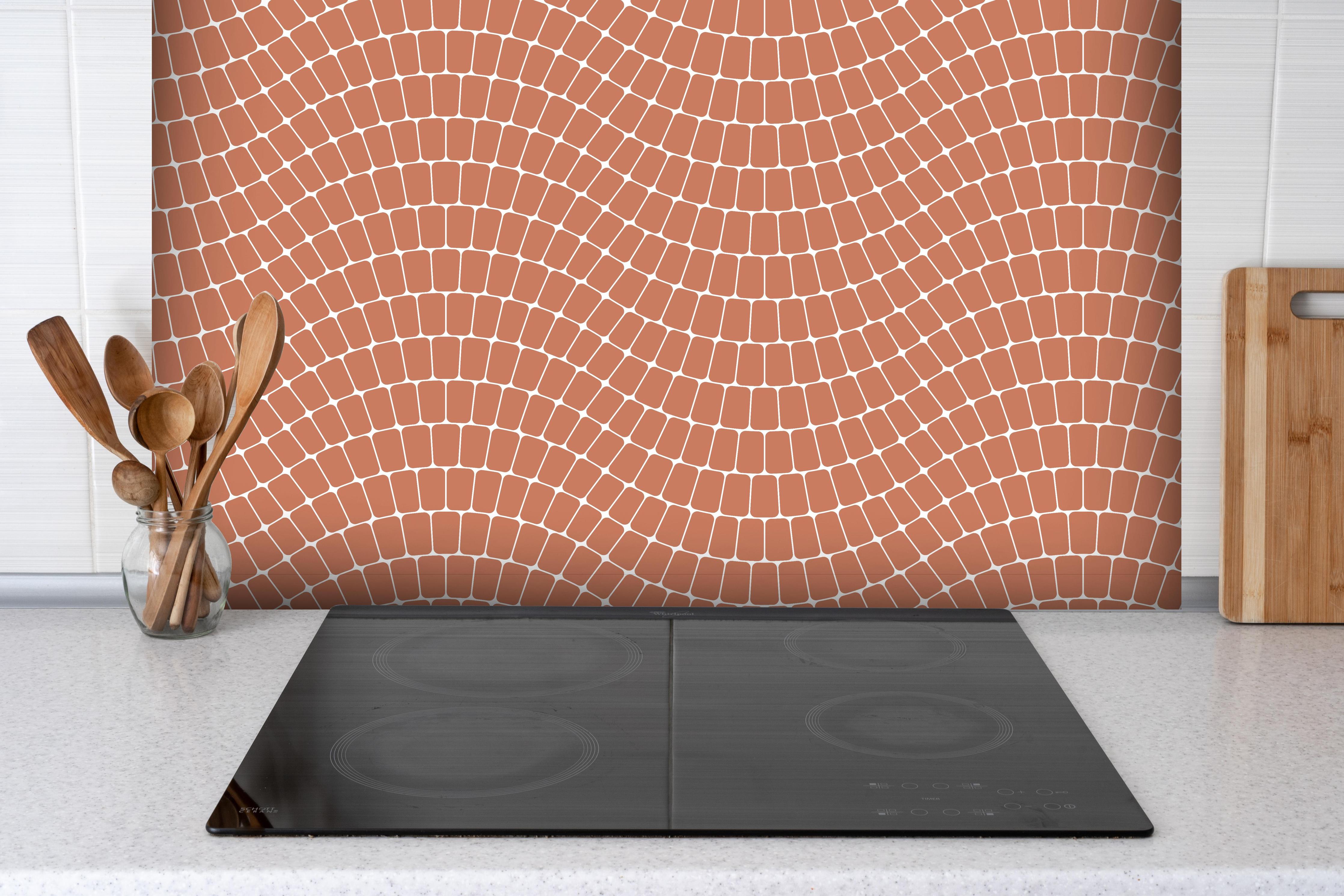 Spritzschutz - Onde Sinuoso Terracotta hinter einem Cerankochfeld zwischen Holz-Kochutensilien